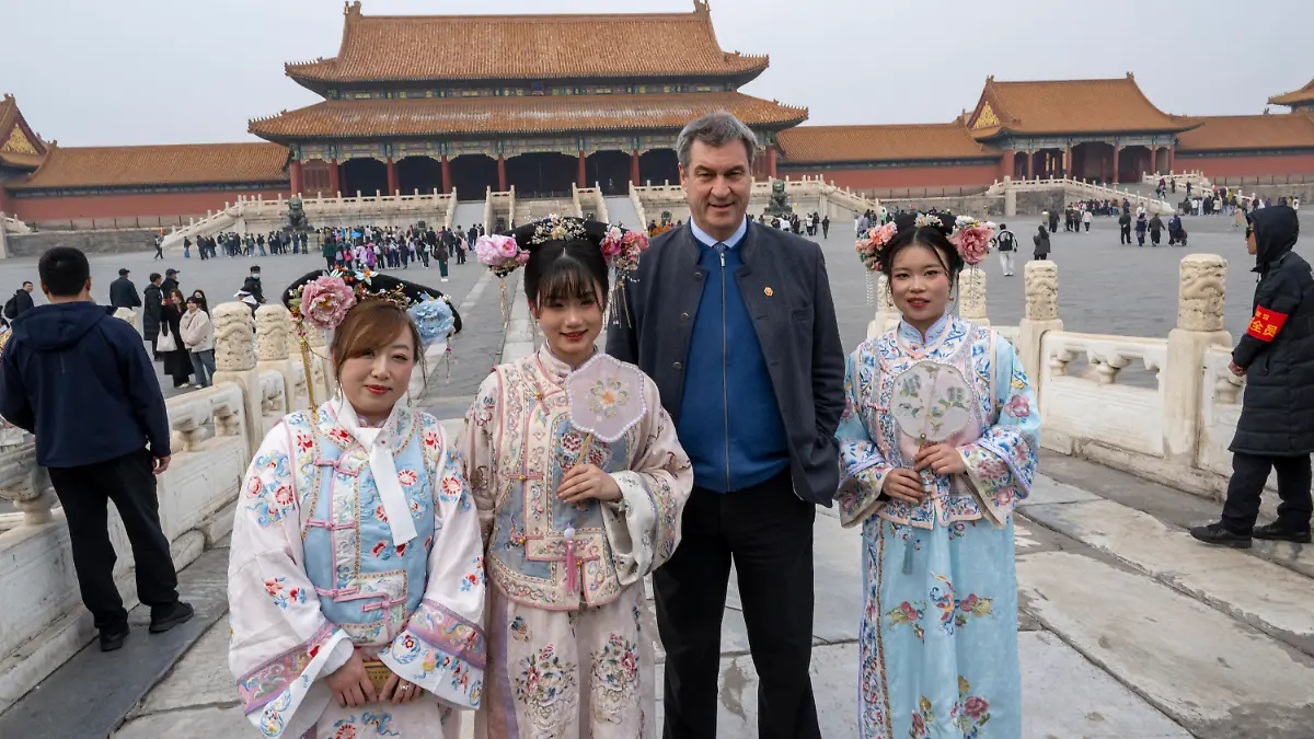 26.03.2024, China, Peking: Markus Söder (CSU), Ministerpräsident von Bayern, besucht die historische verbotene Stadt in der chinesischen Hauptstadt und stellt sich für ein Foto neben Frauen in traditionellen Kostümen. Söder bereist bis zum 28.03.2024 die Volksrepublik China. (zu dpa: «Söder dringt in China auf faire Wettbewerbsbedingungen») Foto: Peter Kneffel/dpa +++ dpa-Bildfunk +++