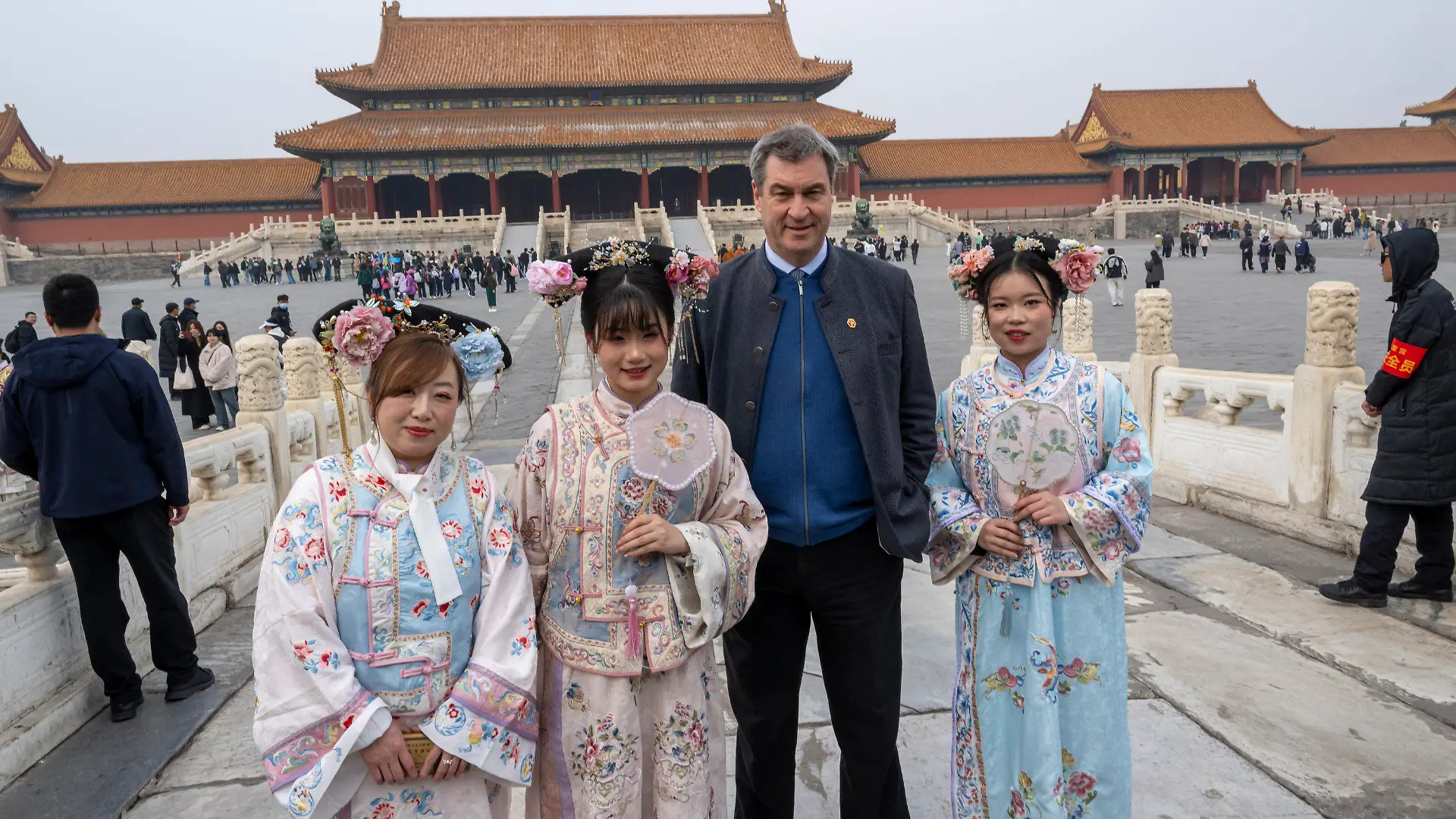 26.03.2024, China, Peking: Markus Söder (CSU), Ministerpräsident von Bayern, besucht die historische verbotene Stadt in der chinesischen Hauptstadt und stellt sich für ein Foto neben Frauen in traditionellen Kostümen. Söder bereist bis zum 28.03.2024 die Volksrepublik China. (zu dpa: «Söder dringt in China auf faire Wettbewerbsbedingungen») Foto: Peter Kneffel/dpa +++ dpa-Bildfunk +++