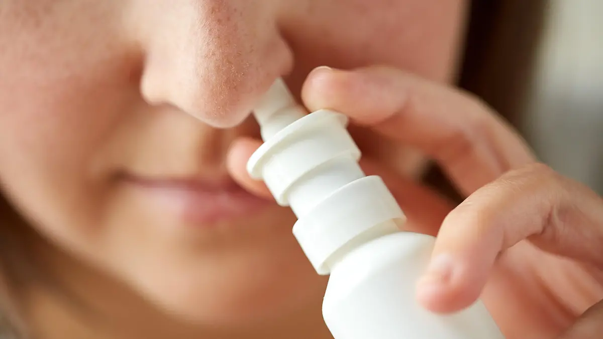 healthcare, flu, rhinitis, medicine and people concept - close up of sick woman using nasal spray