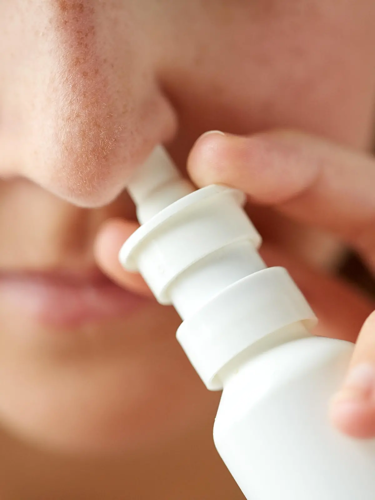 healthcare, flu, rhinitis, medicine and people concept - close up of sick woman using nasal spray
