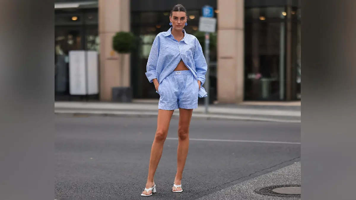 Celine Bethmann wearing blue striped Worst Behavior two piece and white Stradivarius heels on August 16, 2021 in Berlin, Germany.