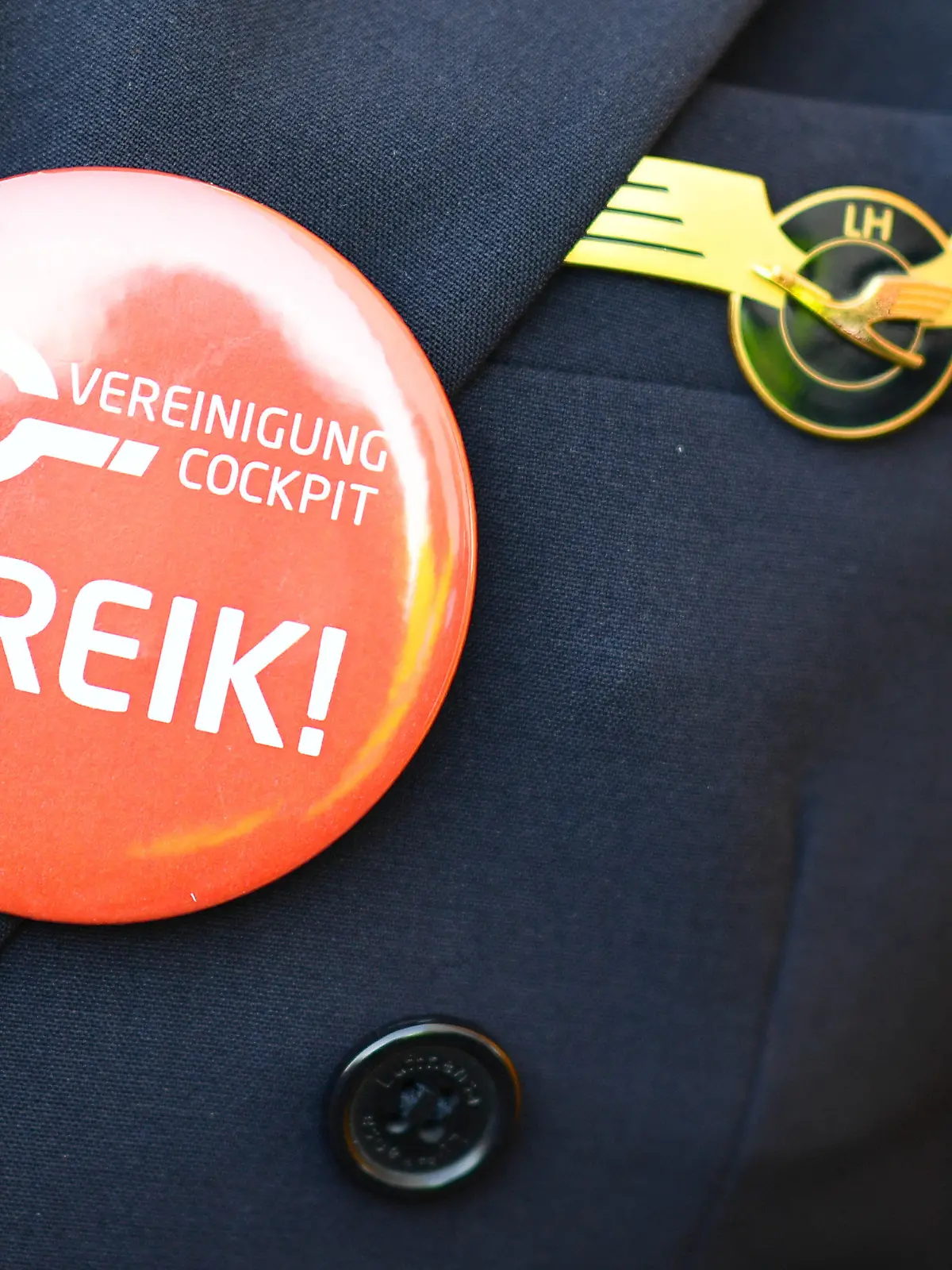 ARCHIV - 30.11.2016, Hessen, Frankfurt/Main: Ein Lufthansa-Pilot trägt bei einer Kundgebung der Pilotengewerkschaft Vereinigung Cockpit einen Button mit der Aufschrift "Streik" auf seiner Uniform. (zu dpa «Lufthansa-Piloten streiken am Freitag») Foto: picture alliance / Uwe Anspach/dpa +++ dpa-Bildfunk +++