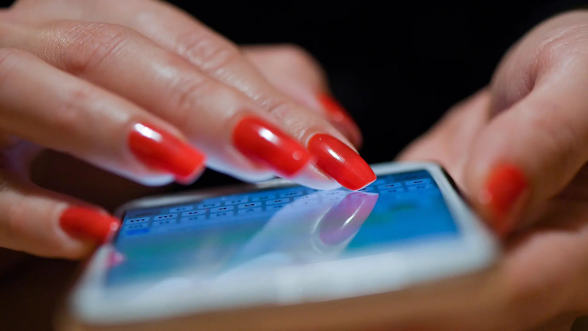 ARCHIV - 08.11.2019, Brandenburg, Sieversdorf: Eine Frau mit roten Fingernägeln schreibt eine Nachricht auf ihrem Smartphone. In Lockdown-Zeiten boomten Online-Dating-Plattformen noch mehr als zuvor - und das wird aus Sicht von Experten auch nach der Corona-Pandemie so bleiben. (zu dpa "Experten: Online-Dating boomt auch nach Corona weiter") Foto: Patrick Pleul/dpa-Zentralbild/dpa +++ dpa-Bildfunk +++