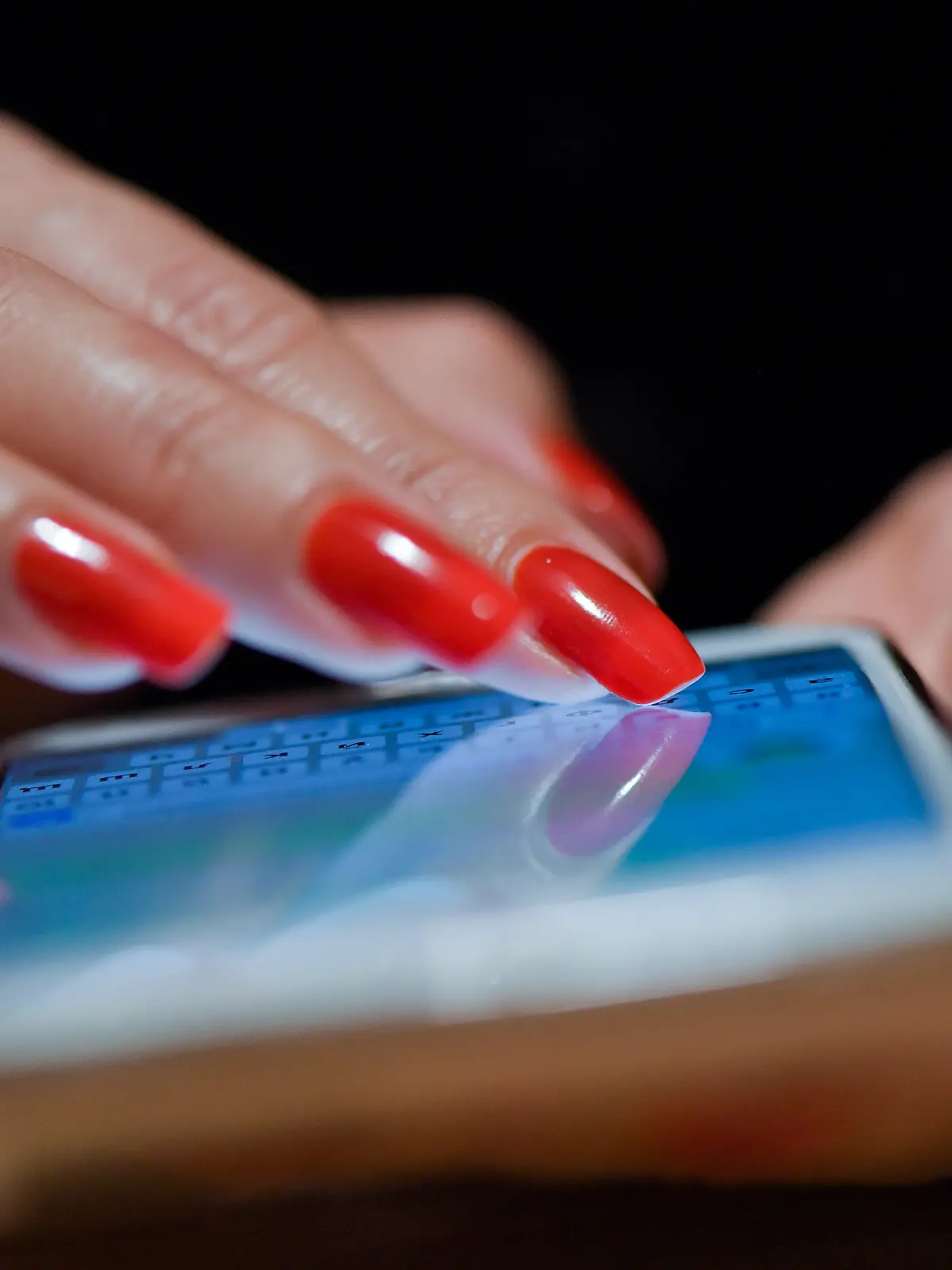 ARCHIV - 08.11.2019, Brandenburg, Sieversdorf: Eine Frau mit roten Fingernägeln schreibt eine Nachricht auf ihrem Smartphone. In Lockdown-Zeiten boomten Online-Dating-Plattformen noch mehr als zuvor - und das wird aus Sicht von Experten auch nach der Corona-Pandemie so bleiben. (zu dpa "Experten: Online-Dating boomt auch nach Corona weiter") Foto: Patrick Pleul/dpa-Zentralbild/dpa +++ dpa-Bildfunk +++