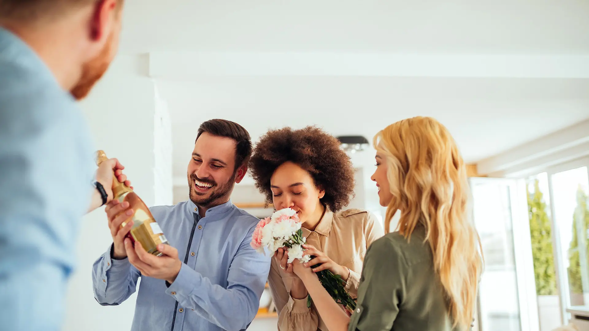 Cheerful friends celebrating moving into new apartment