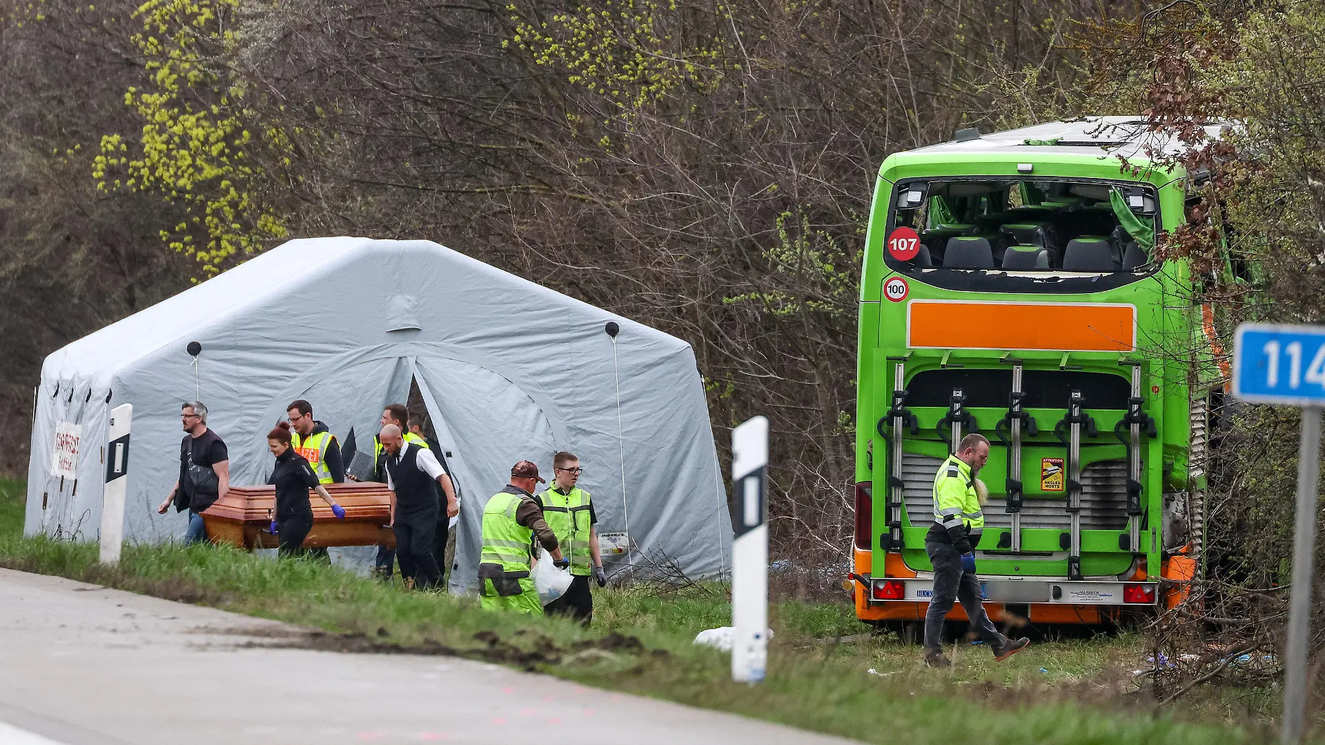 27.03.2024, Sachsen, Schkeuditz: Bestatter tragen ein Todesopfer des verunglückten Busses von der Unfallstelle auf der A9. Bei dem Unfall mit einem Reisebus auf der A9 nahe Leipzig sind mindestens fünf Menschen ums Leben gekommen. Dies teilte die Polizei auf Anfrage mit. Zudem gab es bei dem Unfall zahlreiche Verletzte. Foto: Jan Woitas/dpa - ACHTUNG: Kennzeichen wurde aus rechtlichen Gründen gepixelt +++ dpa-Bildfunk +++
