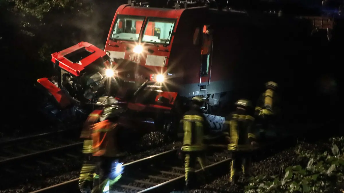 31.08.2022, Hessen, Kirchhain: Feuerwehrleute arbeiten an der Unfallstelle zwischen einem Traktor und der Lok eines Güterzugs. Die Bahnstrecke bei Kirchhain ist seit Mittwochabend gesperrt. Ob jemand verletzt wurde, war zunächst unklar. Foto: Nadine Weigel/dpa +++ dpa-Bildfunk +++