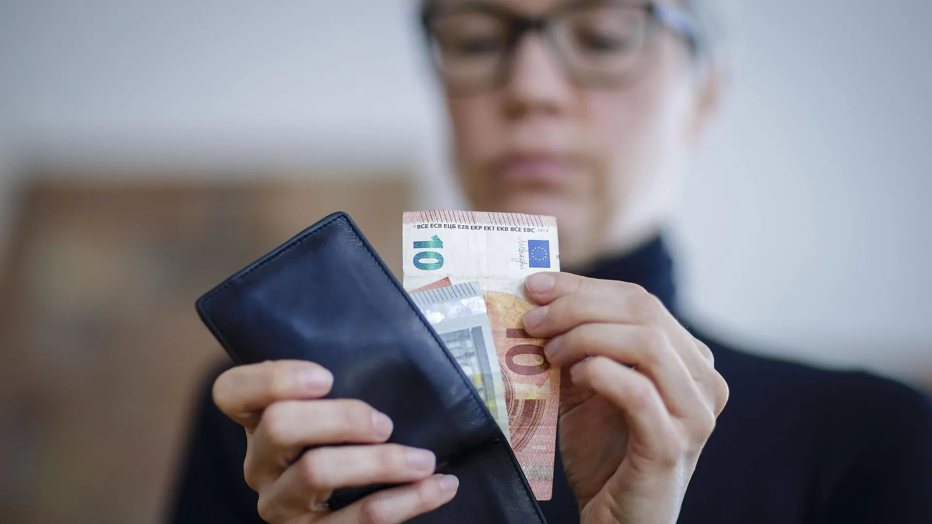 Symbolfoto. Eine Frau nimmt Geldscheine aus einer Geldboerse. Berlin, 06.04.2020. Berlin Deutschland *** Symbol photo A woman takes bank notes from a money exchange Berlin, 06 04 2020 Berlin Germany Copyright: xThomasxTrutschel/photothekx