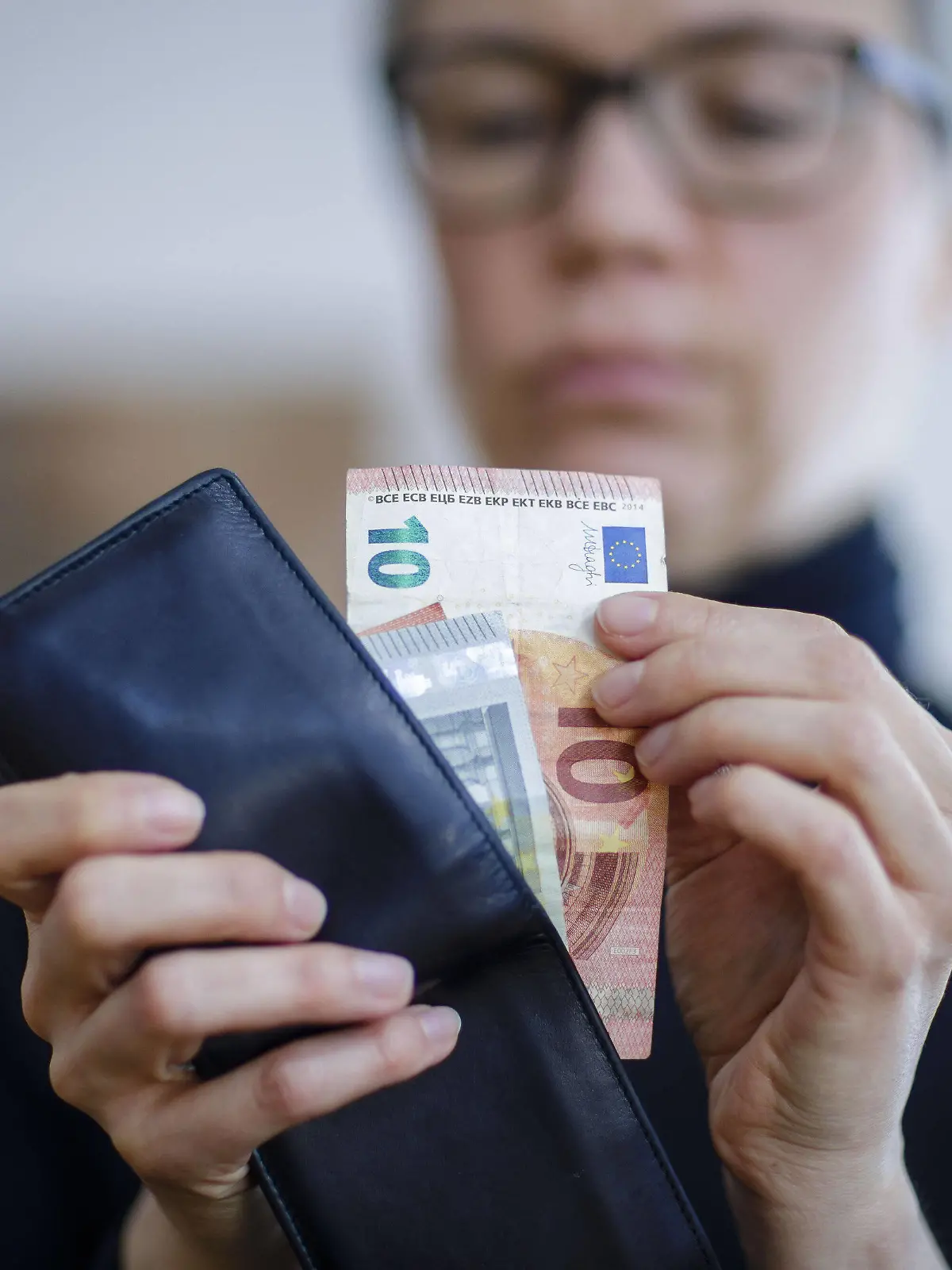  Symbolfoto. Eine Frau nimmt Geldscheine aus einer Geldboerse. Berlin, 06.04.2020. Berlin Deutschland *** Symbol photo A woman takes bank notes from a money exchange Berlin, 06 04 2020 Berlin Germany Copyright: xThomasxTrutschel/photothekx