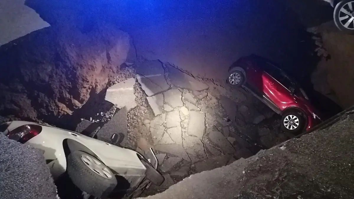 HANDOUT - 28.03.2024, Italien, Rom: Autos liegen in einem riesigen Erdloch. Das ungefähr zehn Meter tiefe Loch mit einem Durchmesser von ebenfalls zirka zehn Metern hatte sich aus bisher ungeklärter Ursache in der Nacht zum 28.03.2024 aufgetan und zwei geparkte Autos in die Tiefe gerissen. Foto: Polizia Roma Capitale/dpa - ACHTUNG: Nur zur redaktionellen Verwendung im Zusammenhang mit der aktuellen Berichterstattung und nur mit vollständiger Nennung des vorstehenden Credits +++ dpa-Bildfunk +++
