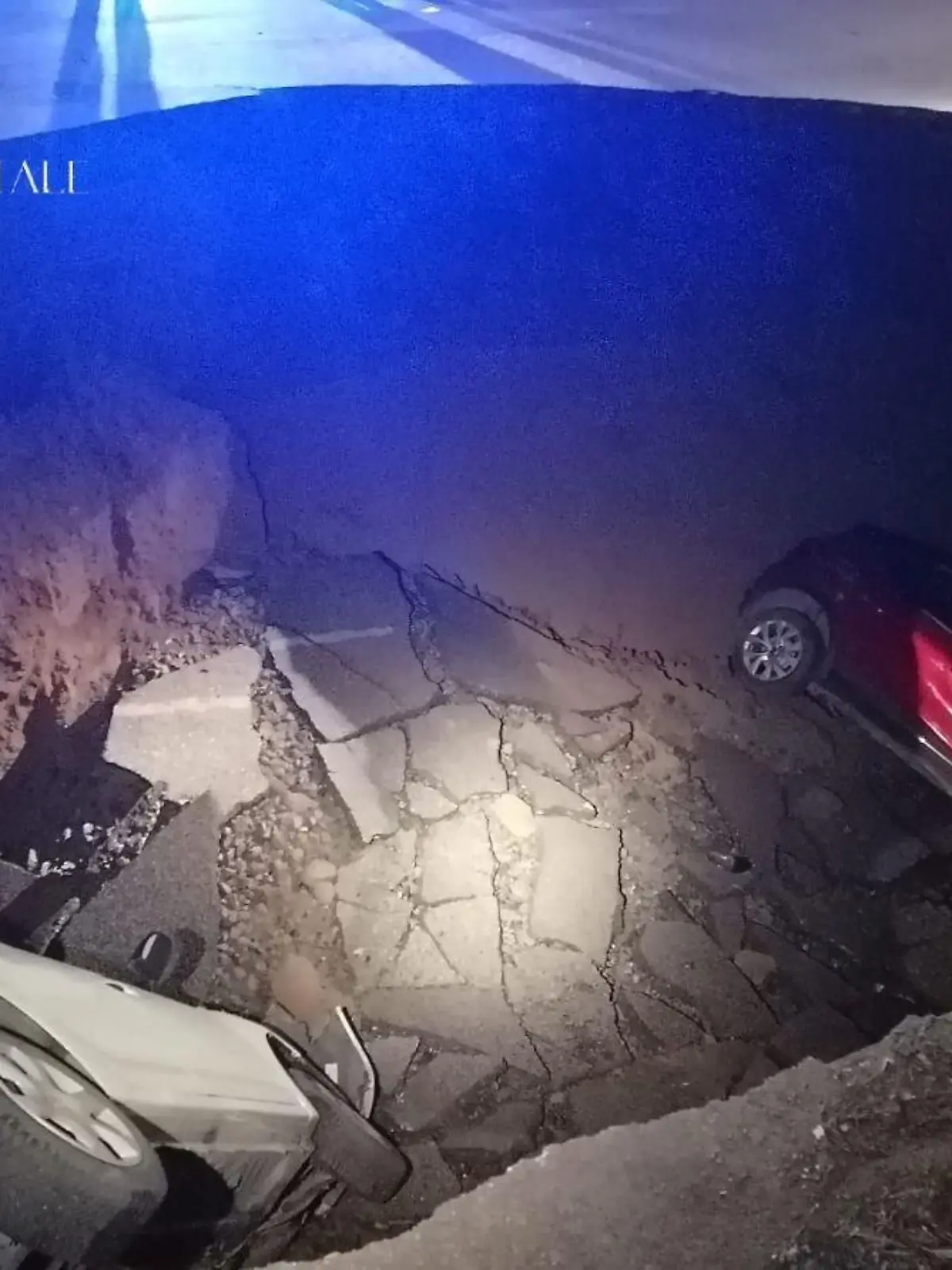 HANDOUT - 28.03.2024, Italien, Rom: Autos liegen in einem riesigen Erdloch. Das ungefähr zehn Meter tiefe Loch mit einem Durchmesser von ebenfalls zirka zehn Metern hatte sich aus bisher ungeklärter Ursache in der Nacht zum 28.03.2024 aufgetan und zwei geparkte Autos in die Tiefe gerissen. Foto: Polizia Roma Capitale/dpa - ACHTUNG: Nur zur redaktionellen Verwendung im Zusammenhang mit der aktuellen Berichterstattung und nur mit vollständiger Nennung des vorstehenden Credits +++ dpa-Bildfunk +++