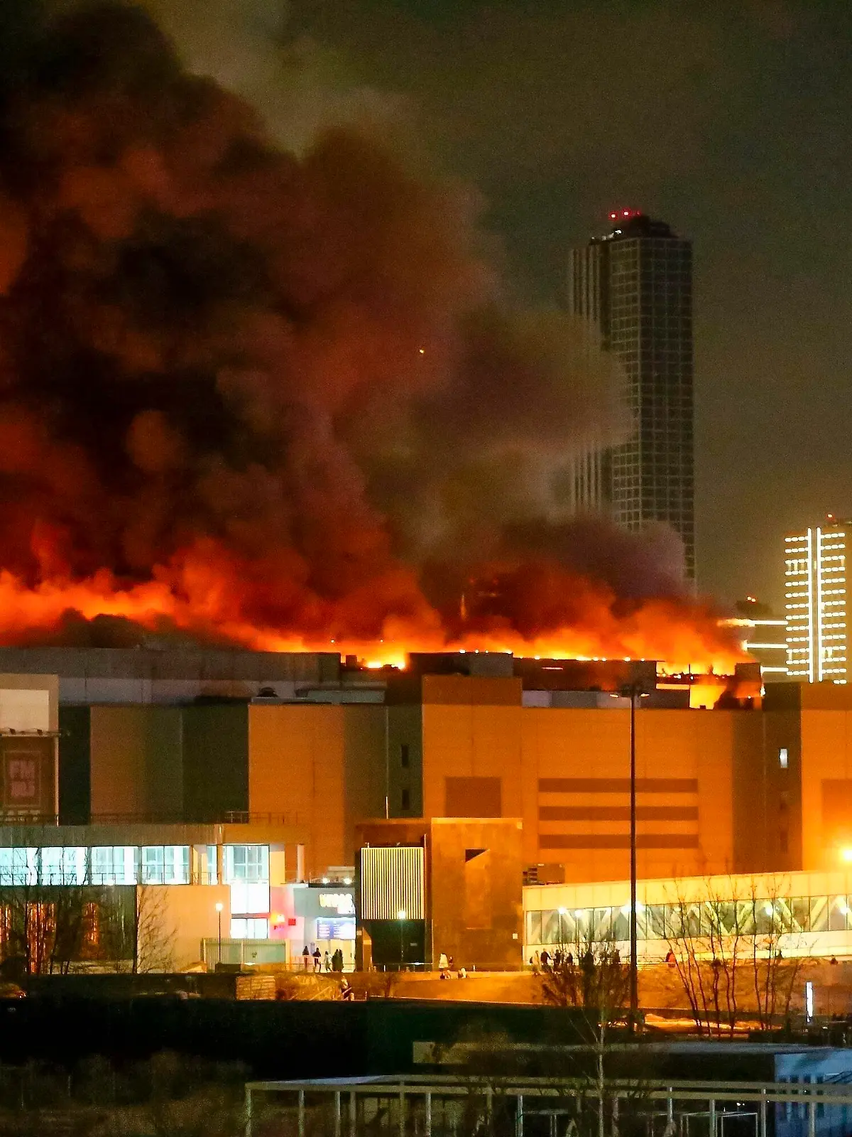 ARCHIV - 22.03.2024, Russland, Moskau: Ein massiver Brand ist am Freitag, 22.03.2024 über dem Crocus City Hall am westlichen Rand von Moskau zu sehen. Der Terroranschlag bei Moskau ist nach den Worten von Kremlchef Wladimir Putin von Islamisten ausgeführt worden. (zu dpa «Putin: Terroranschlag von Islamisten ausgeführt») Foto: Sergei Vedyashkin/Moscow News Agency/AP/dpa +++ dpa-Bildfunk +++