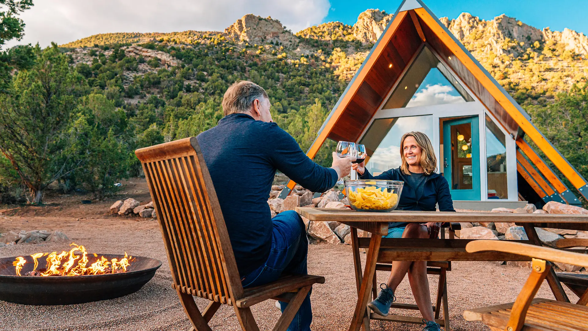 Cute Middle Aged Caucasian Couple Sharing Dinner and Wine Together in Front of a Modern Xeriscaped Tiny House in the Unaweep Canyon along Highway 141 in Western Colorado near Thimble Rock Point and Uncompahgre National Forest