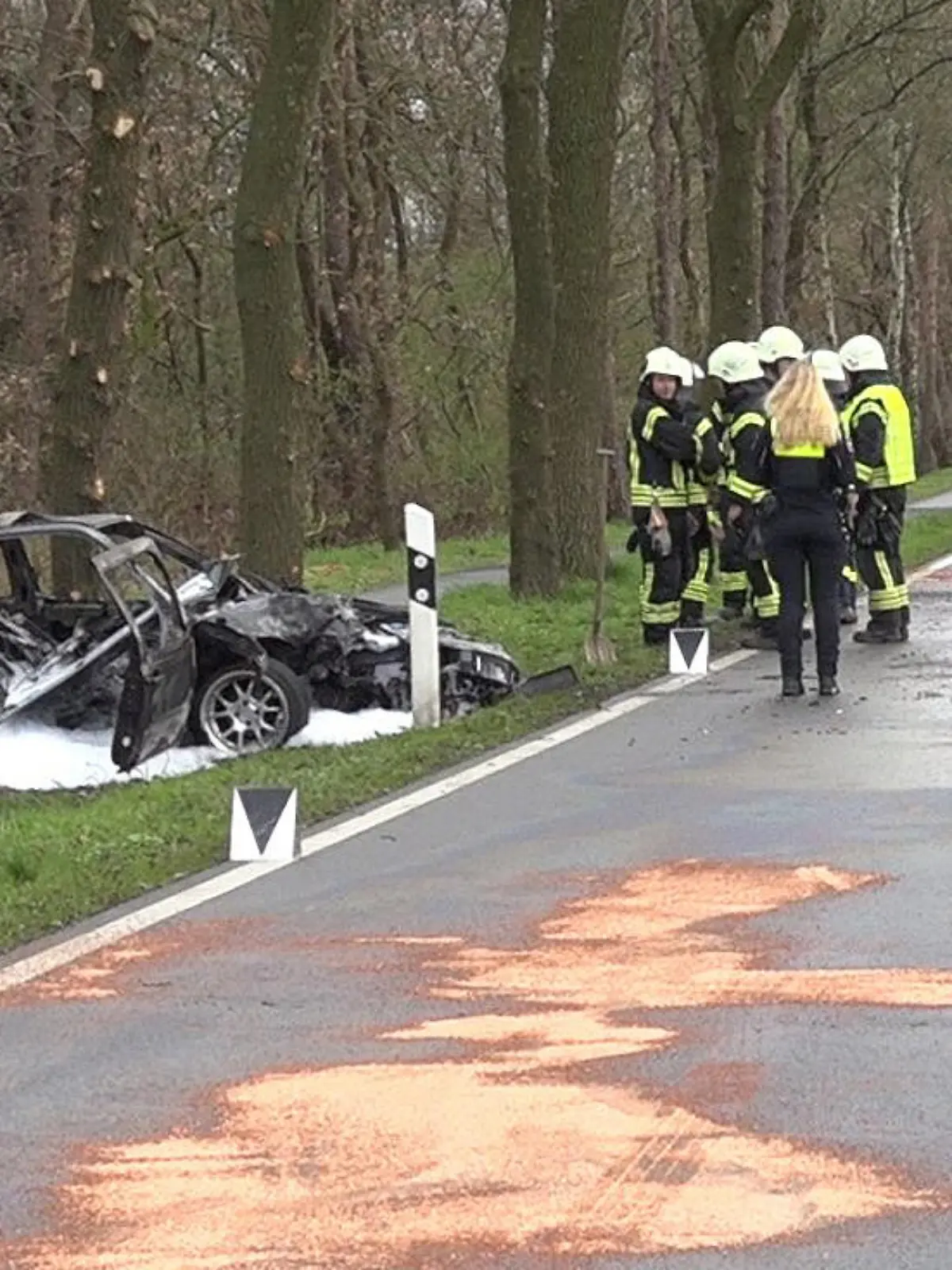 29.03.2024, Niedersachsen, Spahnharrenstätte: Nach einem schweren Unfall in Spahnharrenstätte in der Samtgemeinde Sögel im Landkreis Emsland stehen Einsatzkräfte an der Unfallstelle. Die Fahrerin und der Beifahrer des Autos schweben nach dem Crash in Lebensgefahr. Zwei Kinder wurden schwer verletzt. Der Wagen sei am Freitagvormittag (29.03.2024) ersten Erkenntnissen nach von der Straße abgekommen, sagte ein Polizeisprecher. Dort prallte er gegen einen Baum. Foto: -/NMW-TV/dpa +++ dpa-Bildfunk +++