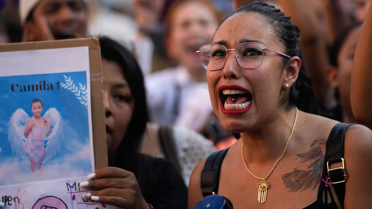 A woman chants the Spanish word for "justice" during a demonstration protesting the kidnapping and killing of an 8-year-old girl, in the main square of Taxco, Mexico, Thursday, March 28, 2024. Hours earlier a mob beat a woman to death because she was suspected of kidnapping and killing the young girl. (AP Photo/Fernando Llano)