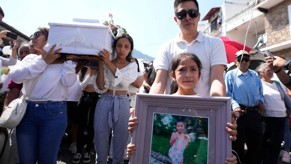 Relatives carry the coffin that contain the remains of a young girl named Camila, in Taxco, Mexico, Friday, March 29, 2024. The 8-year-old girl disappeared Wednesday; her body was found on a road on the outskirts of the city early Thursday. Later that day a mob beat a woman to death because she was suspected of kidnapping and killing the young girl. (AP Photo/Fernando Llano)