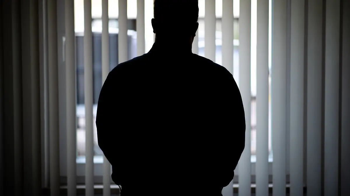 Ein Mann blickt aus einem Fenster.