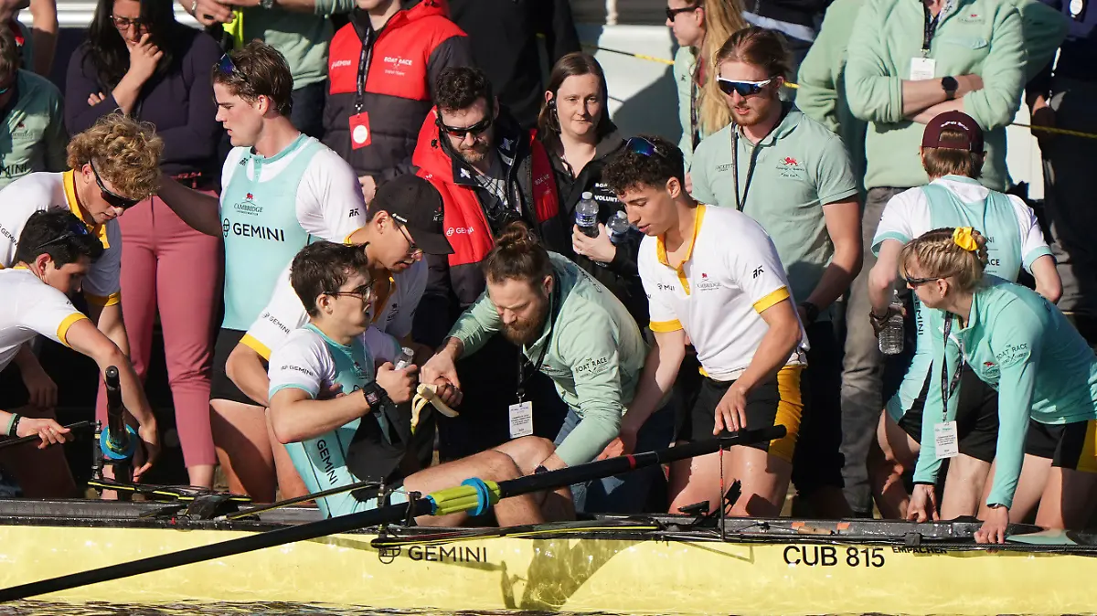 Winning stroke Matt Edge is helped from the boat after the Cambridge Men's team won the 169th Men's Gemini Boat Race 2024 on the River Thames, London, Saturday March 30, 2024. (Joe Giddens/PA via AP)