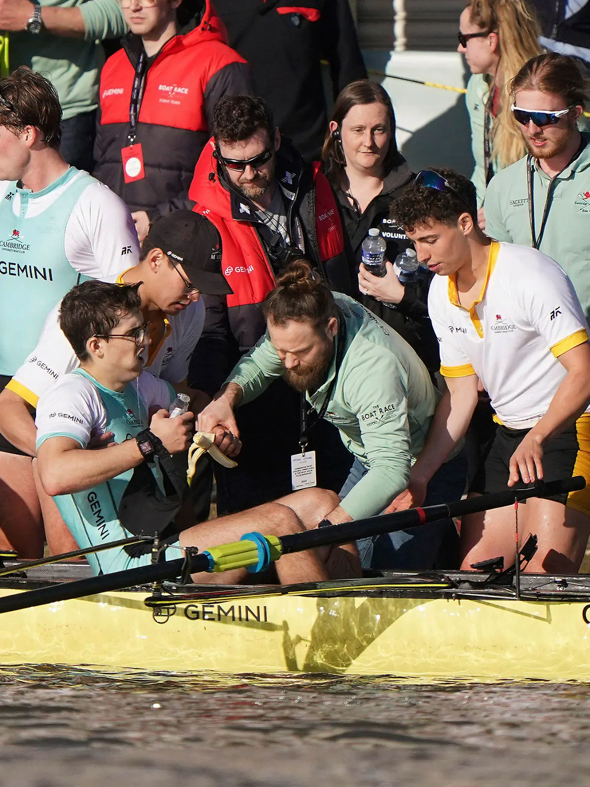 Winning stroke Matt Edge is helped from the boat after the Cambridge Men's team won the 169th Men's Gemini Boat Race 2024 on the River Thames, London, Saturday March 30, 2024. (Joe Giddens/PA via AP)