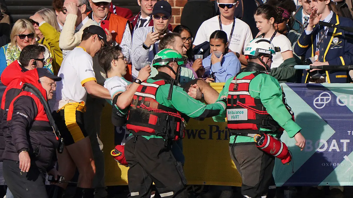 Winning stroke Matt Edge is helped from the boat after the Cambridge Men's team won the 169th Men's Gemini Boat Race 2024 on the River Thames, London, Saturday March 30, 2024. (Joe Giddens/PA via AP)