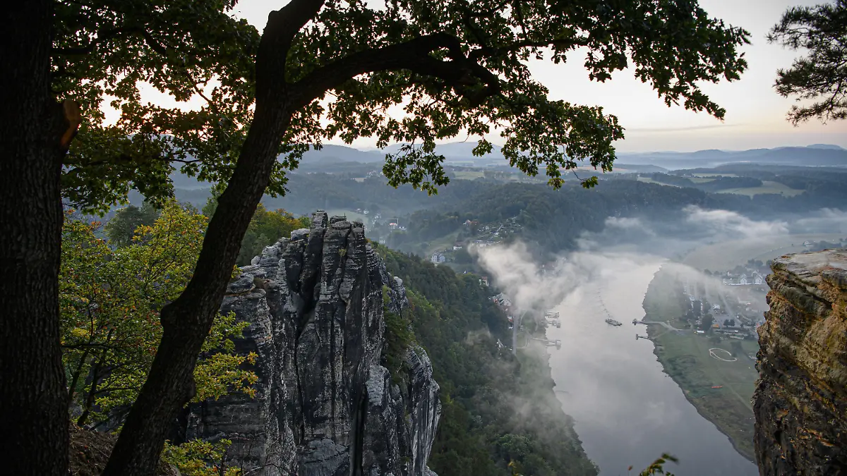 dpatopbilder - 22.09.2020, Sachsen, Rathen: Blick von einer Aussichtsplattform auf der Bastei im Nationalpark Sächsische Schweiz auf das Elbtal im Morgennebel. Foto: Robert Michael/dpa-Zentralbild/dpa +++ dpa-Bildfunk +++
