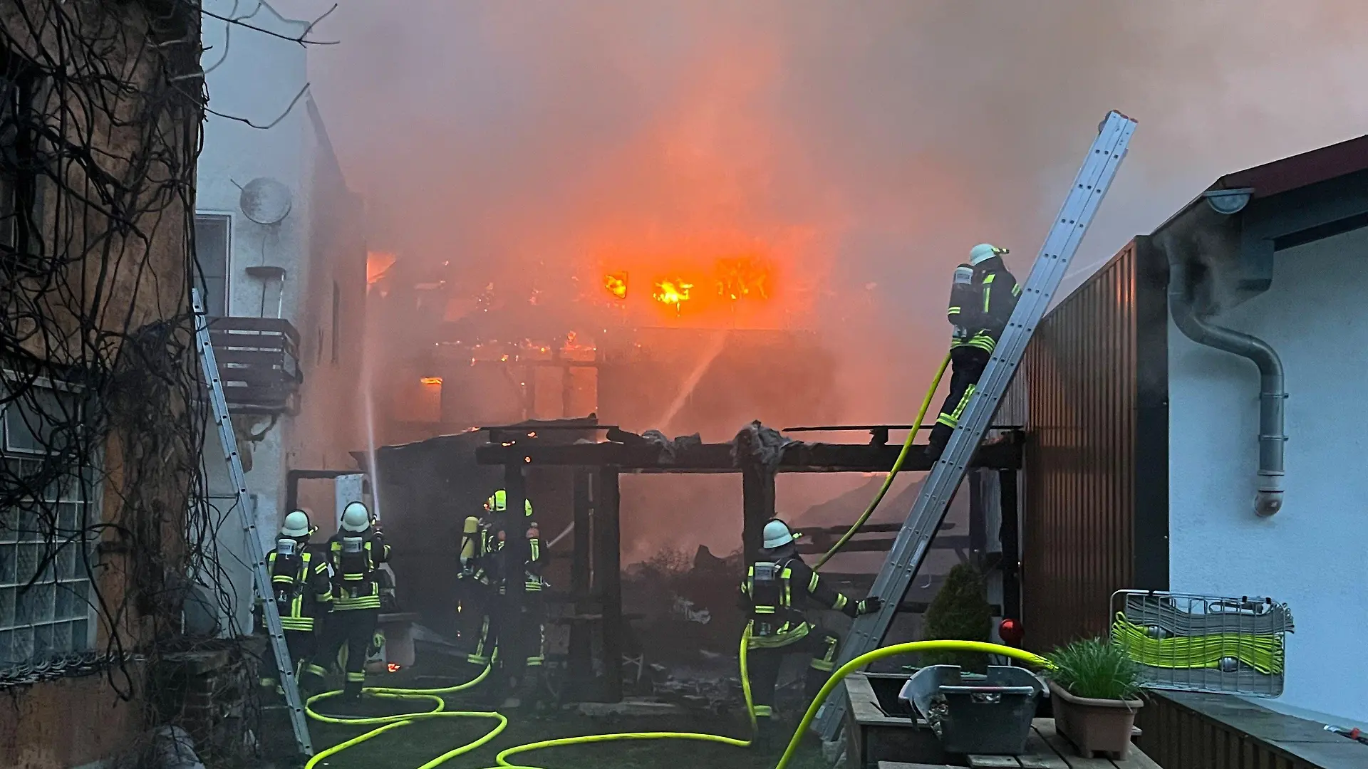 01.04.2024, Bayern, Hofkirchen: Einsatzkräfte der Feuerwehr sind bei Löscharbeiten zwischen Wohnhäusern im Einsatz. Ein Garagenbrand ist in Hofkirchen (Landkreis Passau) auf mindestens fünf angrenzende Wohnhäuser übergegriffen. Der Schaden war bisher nicht einschätzbar, ist aber «von großem Ausmaß», wie die Polizei am Montag miteilte. Foto: Th. Krenn/zema-medien.de/zeema/dpa +++ dpa-Bildfunk +++