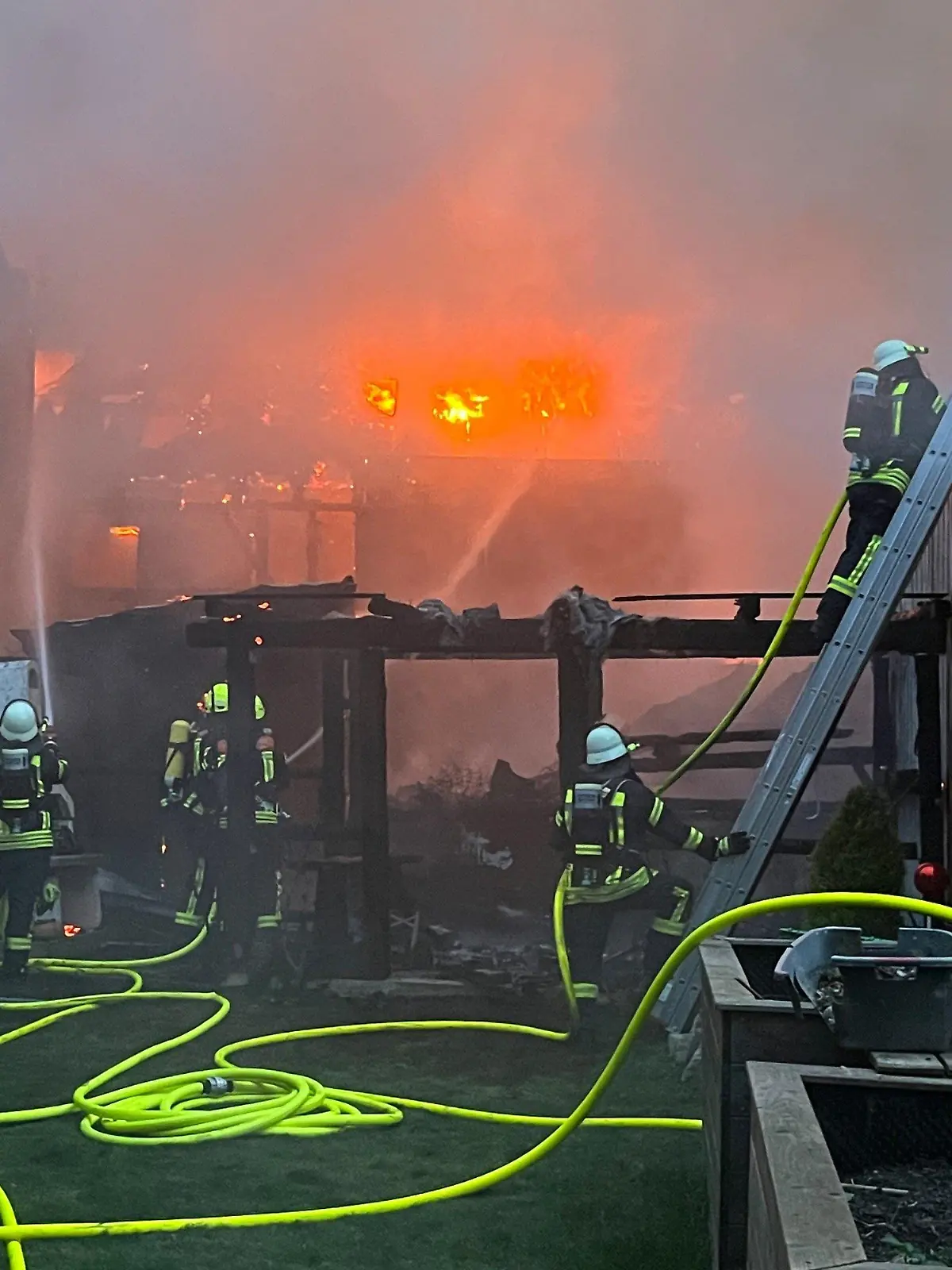 01.04.2024, Bayern, Hofkirchen: Einsatzkräfte der Feuerwehr sind bei Löscharbeiten zwischen Wohnhäusern im Einsatz. Ein Garagenbrand ist in Hofkirchen (Landkreis Passau) auf mindestens fünf angrenzende Wohnhäuser übergegriffen. Der Schaden war bisher nicht einschätzbar, ist aber «von großem Ausmaß», wie die Polizei am Montag miteilte. Foto: Th. Krenn/zema-medien.de/zeema/dpa +++ dpa-Bildfunk +++