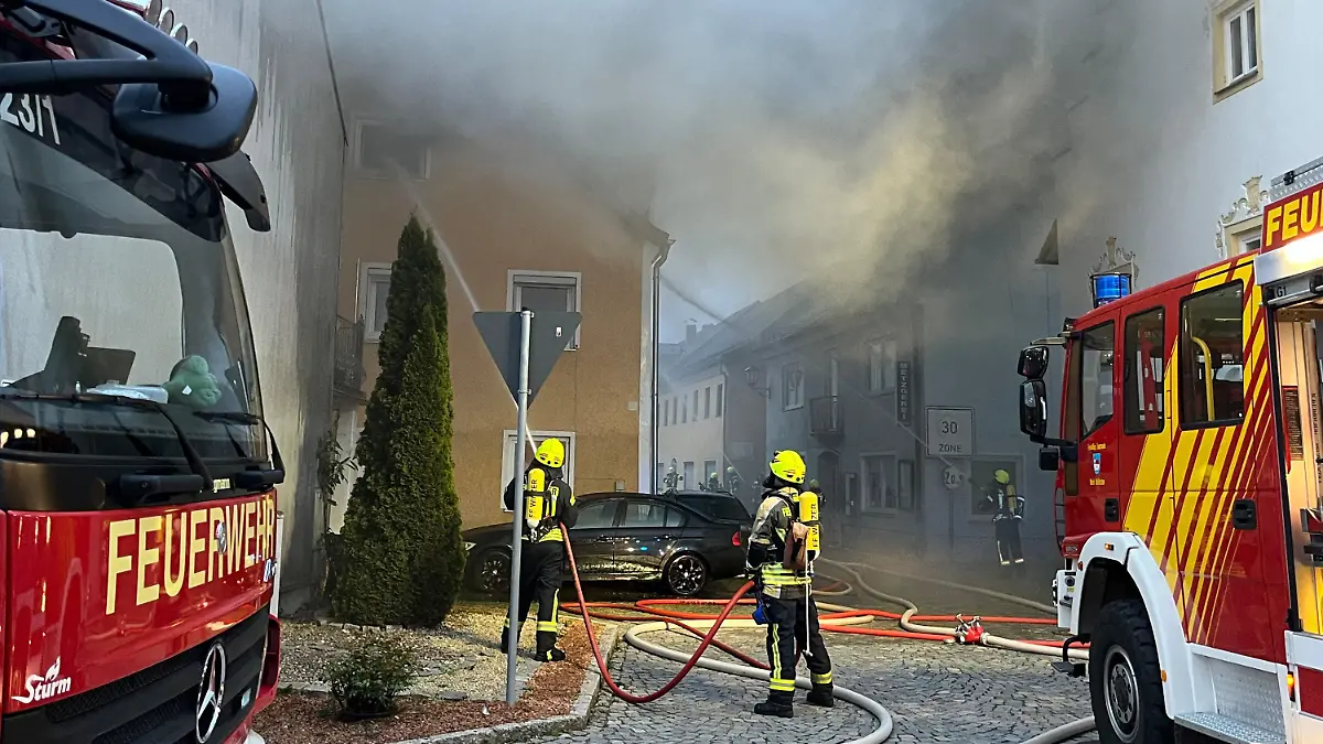 01.04.2024, Bayern, Hofkirchen: Einsatzkräfte der Feuerwehr sind bei Löscharbeiten neben einem Wohnhaus im Einsatz. Ein Garagenbrand ist in Hofkirchen (Landkreis Passau) auf mindestens fünf angrenzende Wohnhäuser übergegriffen. Der Schaden war bisher nicht einschätzbar, ist aber «von großem Ausmaß», wie die Polizei am Montag miteilte. Foto: Th. Krenn/zema-medien.de/zeema/dpa - ACHTUNG:Teile des Bildes (Hausnummer) wurde(n) aus rechtlichen Gründen gepixelt +++ dpa-Bildfunk +++