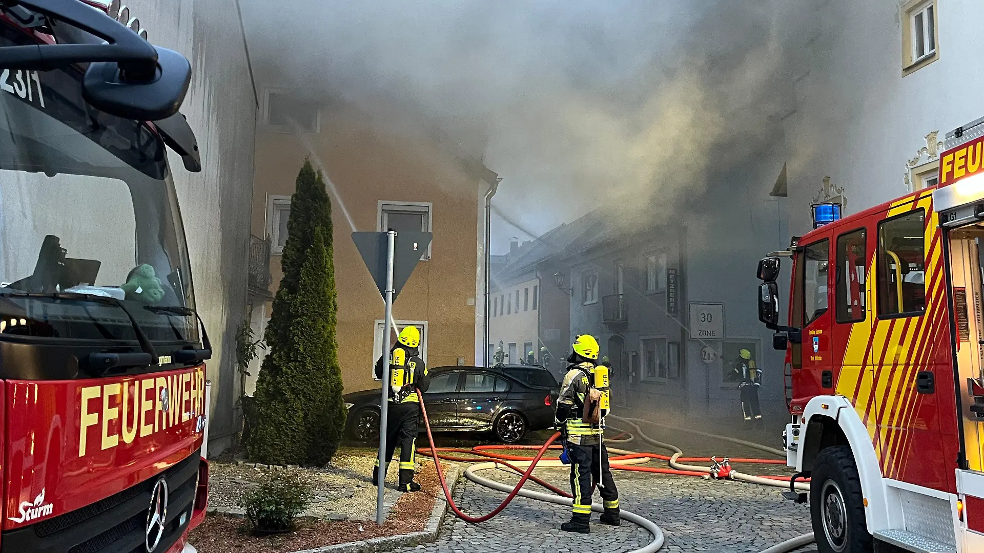 01.04.2024, Bayern, Hofkirchen: Einsatzkräfte der Feuerwehr sind bei Löscharbeiten neben einem Wohnhaus im Einsatz. Ein Garagenbrand ist in Hofkirchen (Landkreis Passau) auf mindestens fünf angrenzende Wohnhäuser übergegriffen. Der Schaden war bisher nicht einschätzbar, ist aber «von großem Ausmaß», wie die Polizei am Montag miteilte. Foto: Th. Krenn/zema-medien.de/zeema/dpa - ACHTUNG:Teile des Bildes (Hausnummer) wurde(n) aus rechtlichen Gründen gepixelt +++ dpa-Bildfunk +++