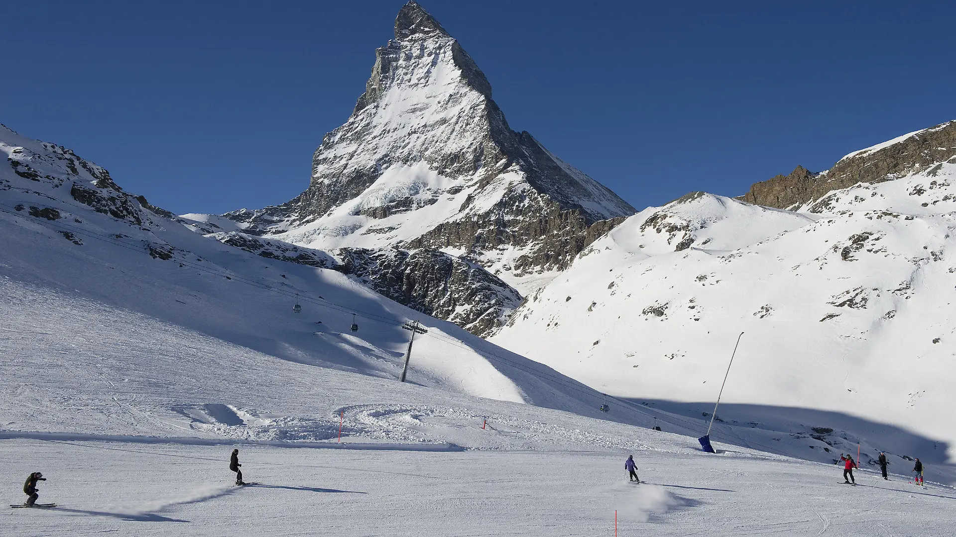 ARCHIV - 16.01.2012, Schweiz, Zermatt: Skifahrer fahren die Pisten am Riffelberg mit dem Matterhorn im Hintergrund hinunter. Eine Lawine soll am Montag in Zermatt in der Schweiz mehrere Menschen mitgerissen haben. Foto: Jean-Christophe Bott/KEYSTONE/dpa +++ dpa-Bildfunk +++