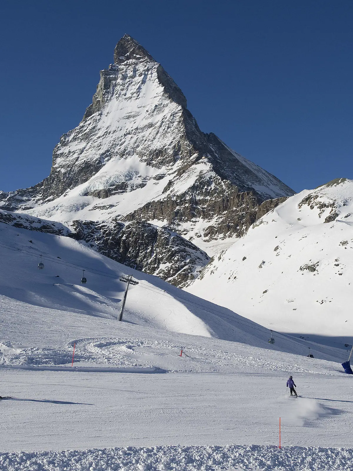 ARCHIV - 16.01.2012, Schweiz, Zermatt: Skifahrer fahren die Pisten am Riffelberg mit dem Matterhorn im Hintergrund hinunter. Eine Lawine soll am Montag in Zermatt in der Schweiz mehrere Menschen mitgerissen haben. Foto: Jean-Christophe Bott/KEYSTONE/dpa +++ dpa-Bildfunk +++