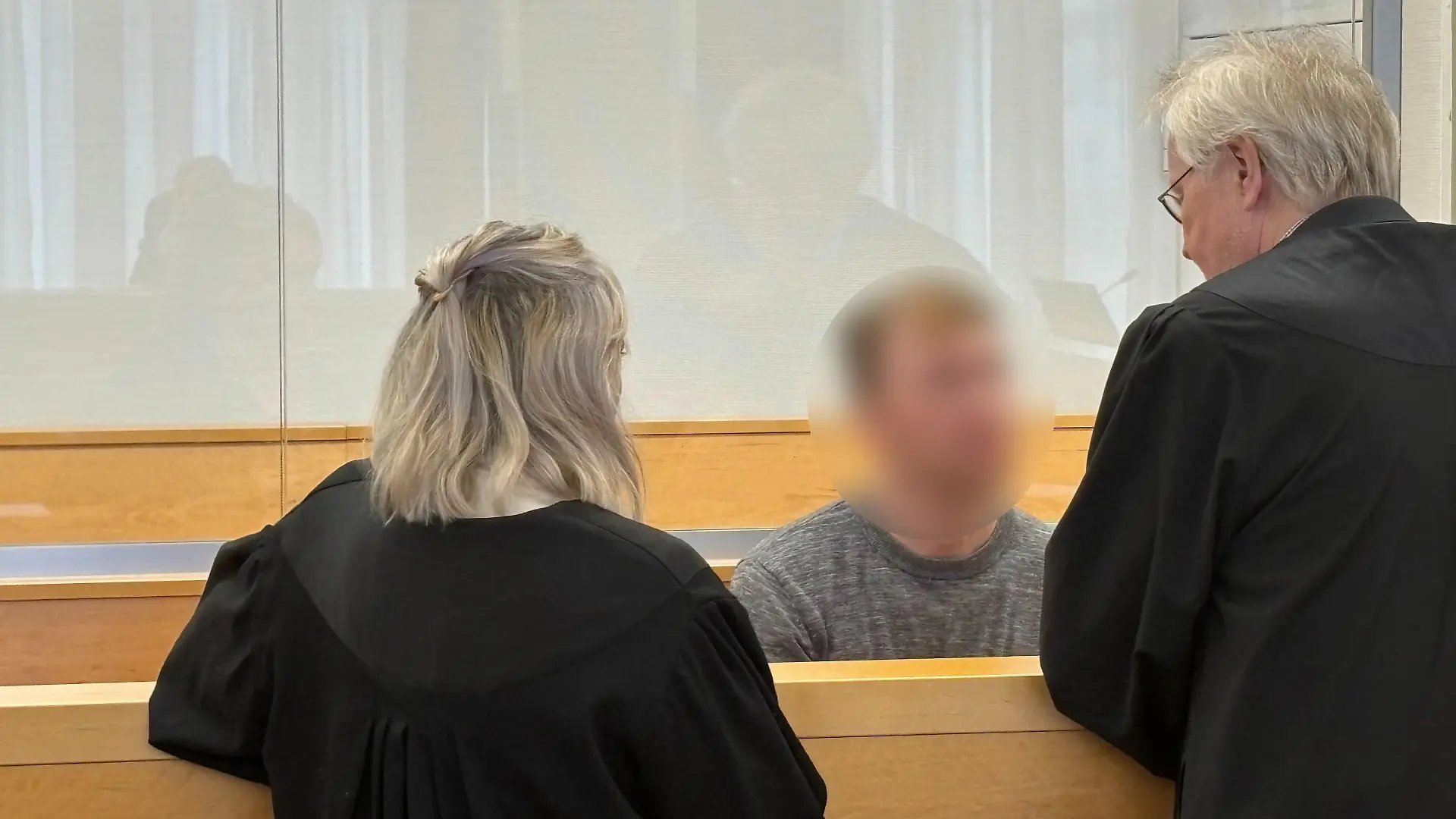 Der angeklagte Alexander K. vor dem Verhandlungstag am Dienstag (2. April) im Gespräch mit seinen Anwälten.