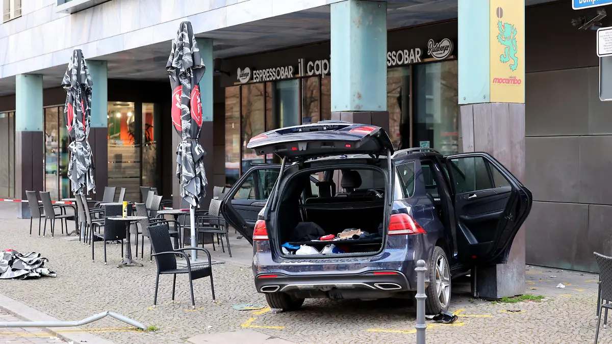 02.04.2024, Sachsen-Anhalt, Magdeburg: Ein Auto steht nach seinem Crash vor dem Cafe-Restaurant "Il Capitello" am Domplatz. Das Auto eines Rentners ist am Dienstagnachmittag in der Magdeburger Innenstadt von der Straße abgekommen und auf die Terrasse des Cafés geraten. Zwei Gäste, die an einem Tisch saßen, wurden verletzt. Der Fahrer, ein 70-Jähriger, habe Bremse und Gaspedal verwechselt. Sein Wagen sei in einer Kurve geradeaus weitergefahren und zwischen zwei Säulen am Außenbereich des Lokals am Domplatz stehen geblieben. Der Unfall werde untersucht. Foto: Peter Gercke/dpa-Zentralbild/dpa +++ dpa-Bildfunk +++
