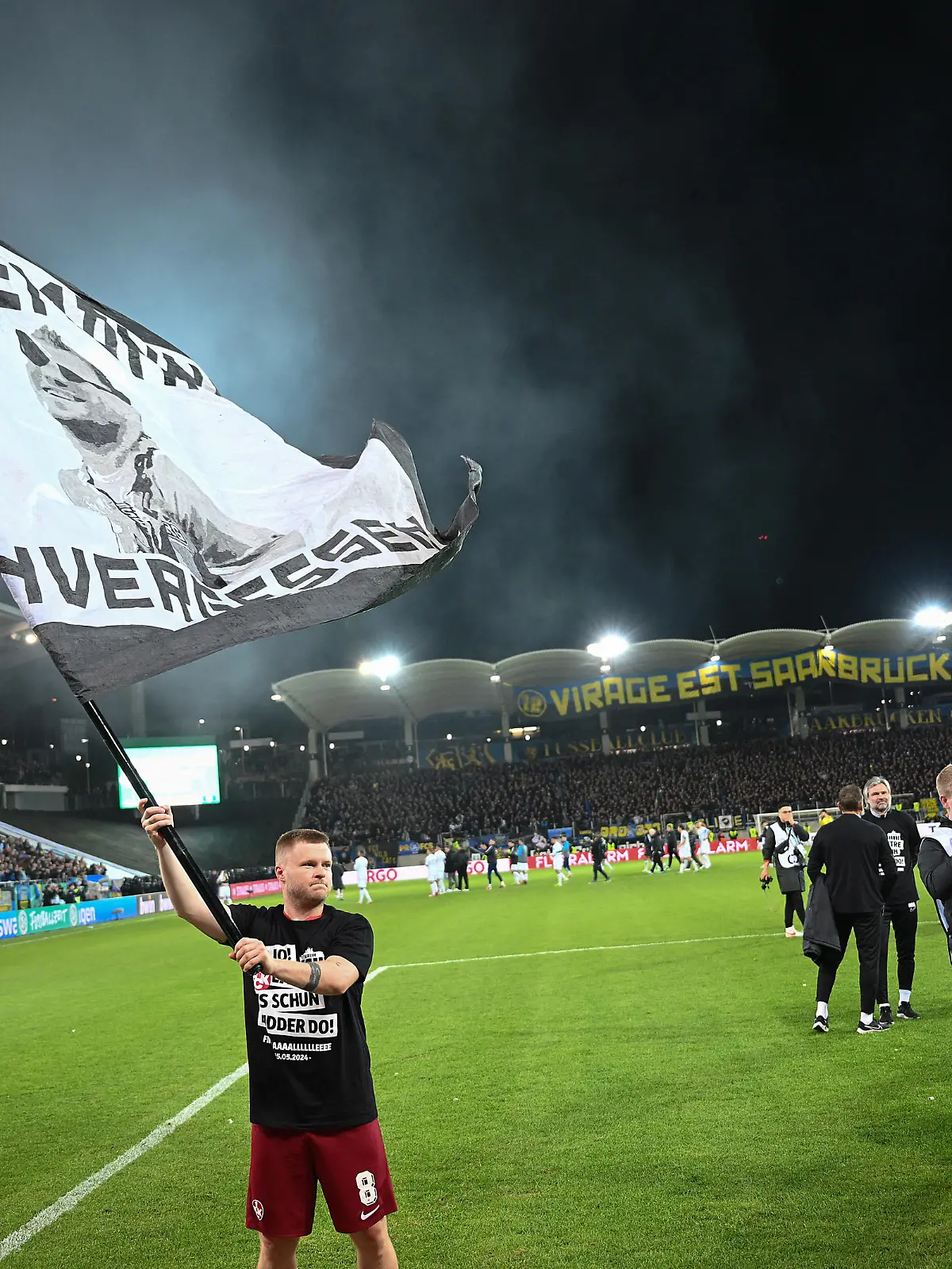 SAARBRUECKEN, GERMANY - APRIL 02: Jean Zimmer of 1. FC Kaiserslautern celebrates after the team's victory with a flag during the DFB Cup semifinal match between 1. FC Saarbrücken and 1. FC Kaiserslautern at the Ludwigsparkstadion on April 02, 2024 in Saarbruecken, Germany. (Photo by Christian Kaspar-Bartke/Getty Images)