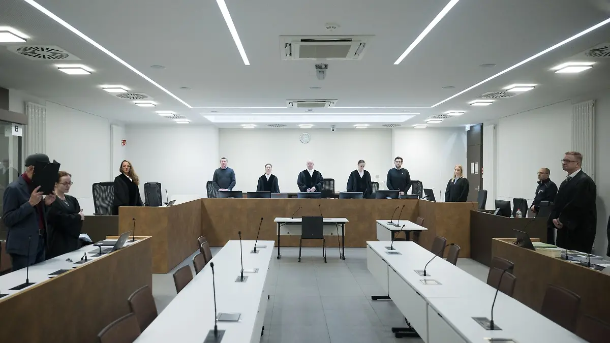 Der Angeklagte hält sich zum Beginn des Prozesses am Kriminalgericht Moabit eine Mappe vor sein Gesicht.