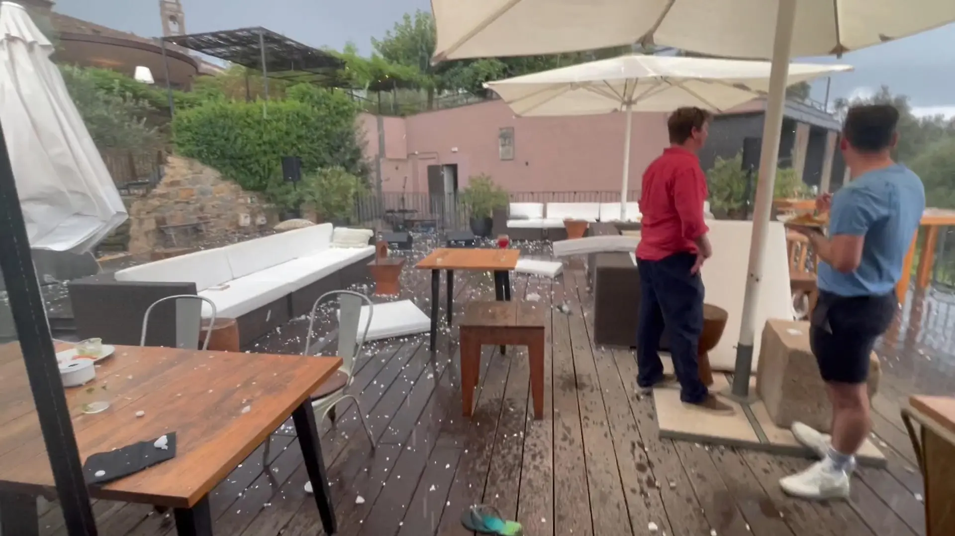 People look on from a hotel during a hailstorm in Girona, Spain August 30, 2022 in this screen grab obtained from a video. Sicus Carbonell via REUTERS THIS IMAGE HAS BEEN SUPPLIED BY A THIRD PARTY. MANDATORY CREDIT. NO RESALES. NO ARCHIVES.