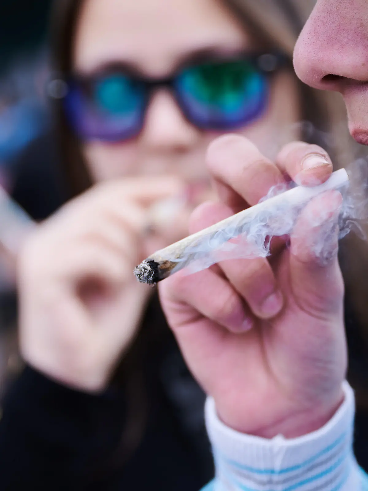 ARCHIV - 20.04.2023, Berlin: Ein Demonstrant raucht einen Joint, während er an der Demonstration ·Entkriminalisierung sofort - für die Freigabe von Cannabis·, vor dem Brandenburger Tor teilnimmt. Der 20. April gilt als Tag der Cannabis-Bewegung, die den Code 420 nutzt. (zu dpa: «Regierungschef Woidke warnt vor Cannabis-Legalisierung») Foto: Annette Riedl/dpa +++ dpa-Bildfunk +++