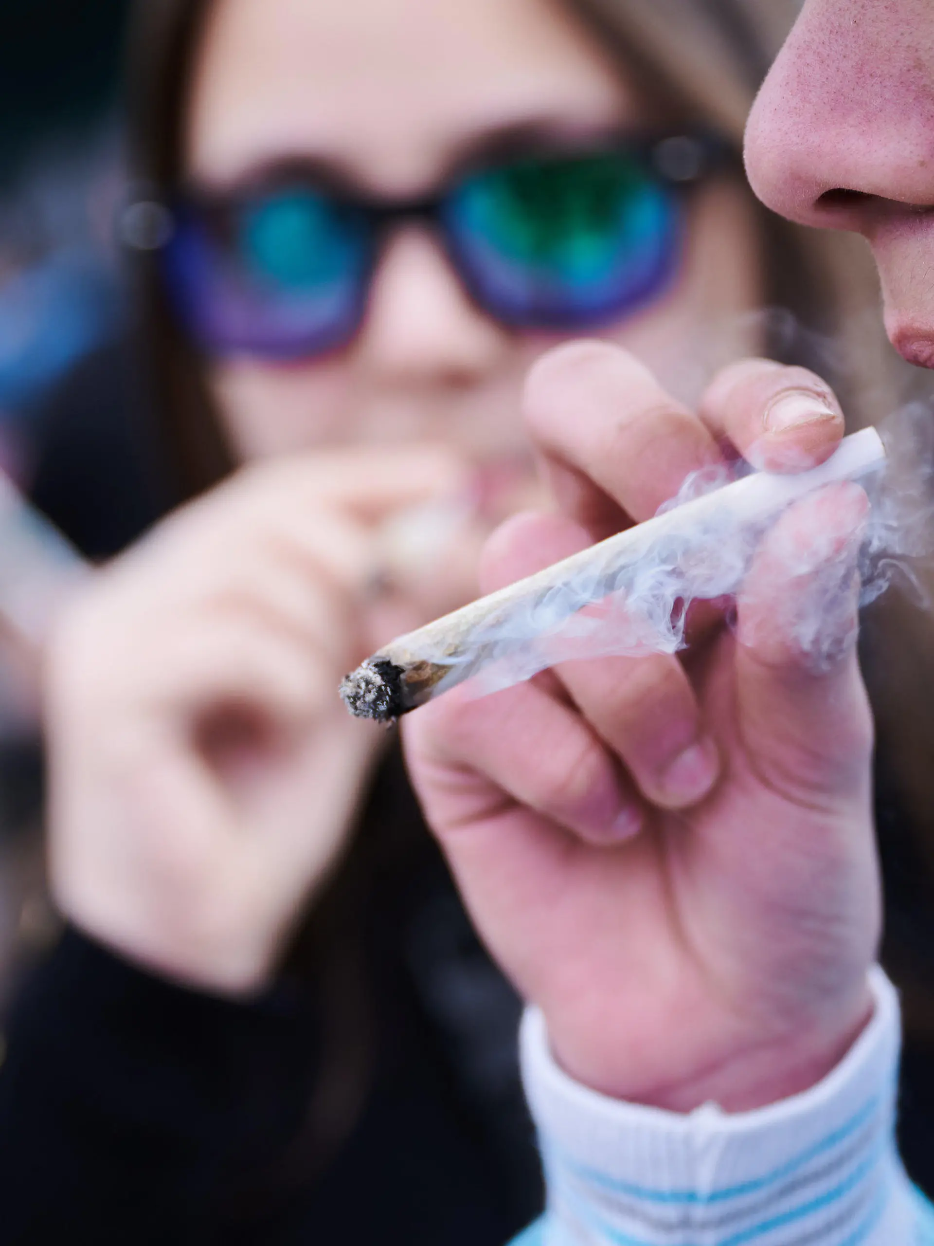 ARCHIV - 20.04.2023, Berlin: Ein Demonstrant raucht einen Joint, während er an der Demonstration ·Entkriminalisierung sofort - für die Freigabe von Cannabis·, vor dem Brandenburger Tor teilnimmt. Der 20. April gilt als Tag der Cannabis-Bewegung, die den Code 420 nutzt. (zu dpa: «Regierungschef Woidke warnt vor Cannabis-Legalisierung») Foto: Annette Riedl/dpa +++ dpa-Bildfunk +++