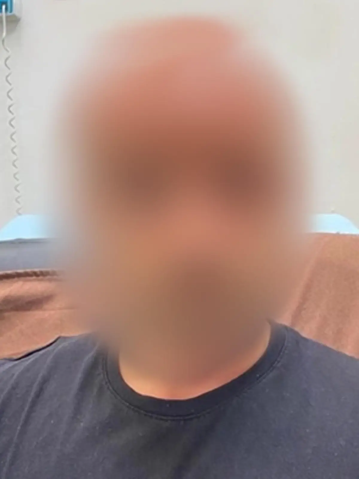 Ein Mann steht gerade vor der Kamera, doch sein Kopf ist geblurrt.