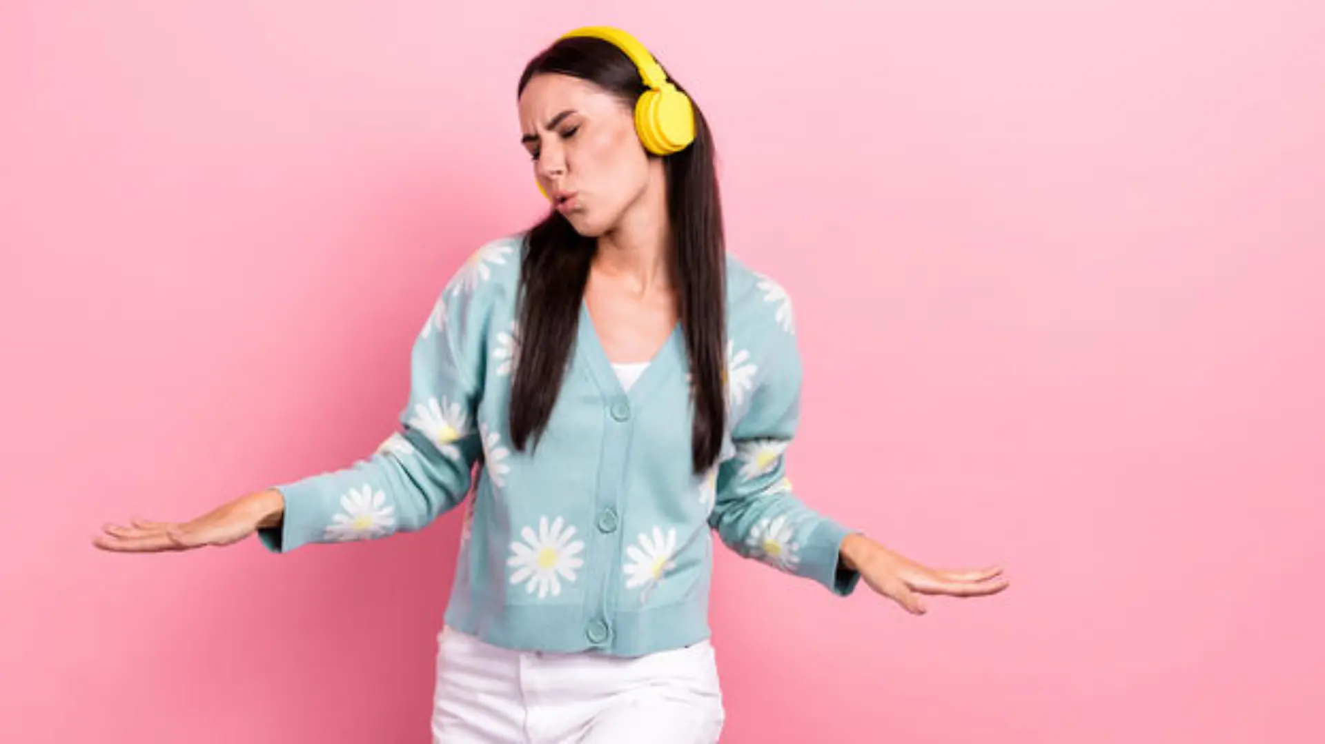 Portrait of good mood lovely girl wear flower print pullover listen pop music in headphones dancing isolated on pink color background.