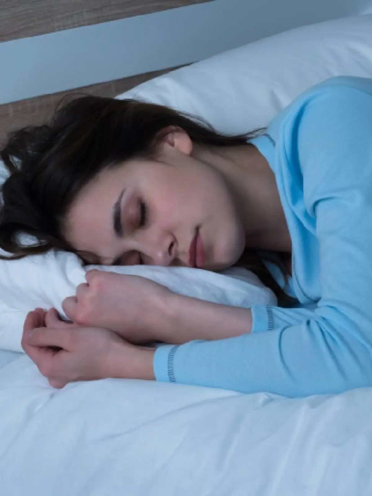 schlafende junge frau auf dem bett in ihrem schlafzimmer