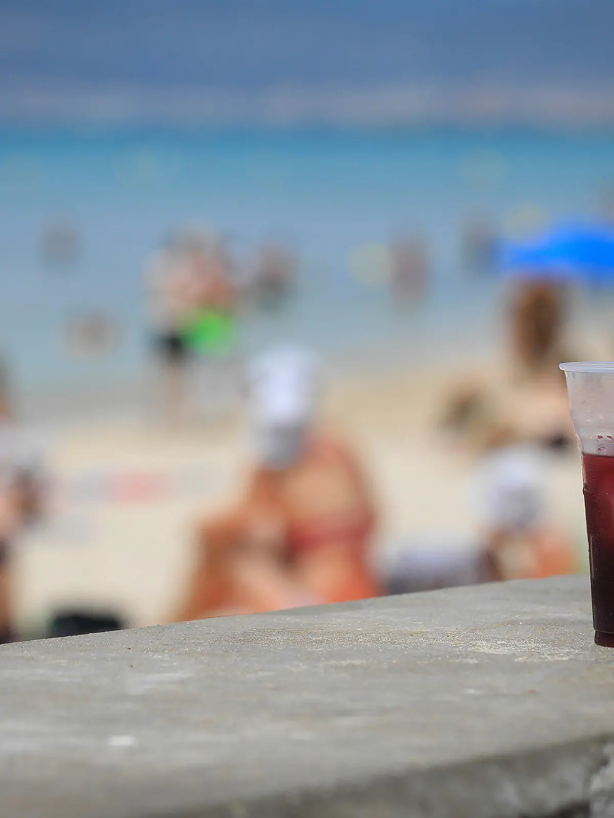 07.07.2023, Spanien, Palma: Ein Glas «Sangria» steht am Strand Arenal an einem warmen Sommertag. Die Party-Saison auf Mallorca ist im vollen Gange. Foto: Clara Margais/dpa +++ dpa-Bildfunk +++