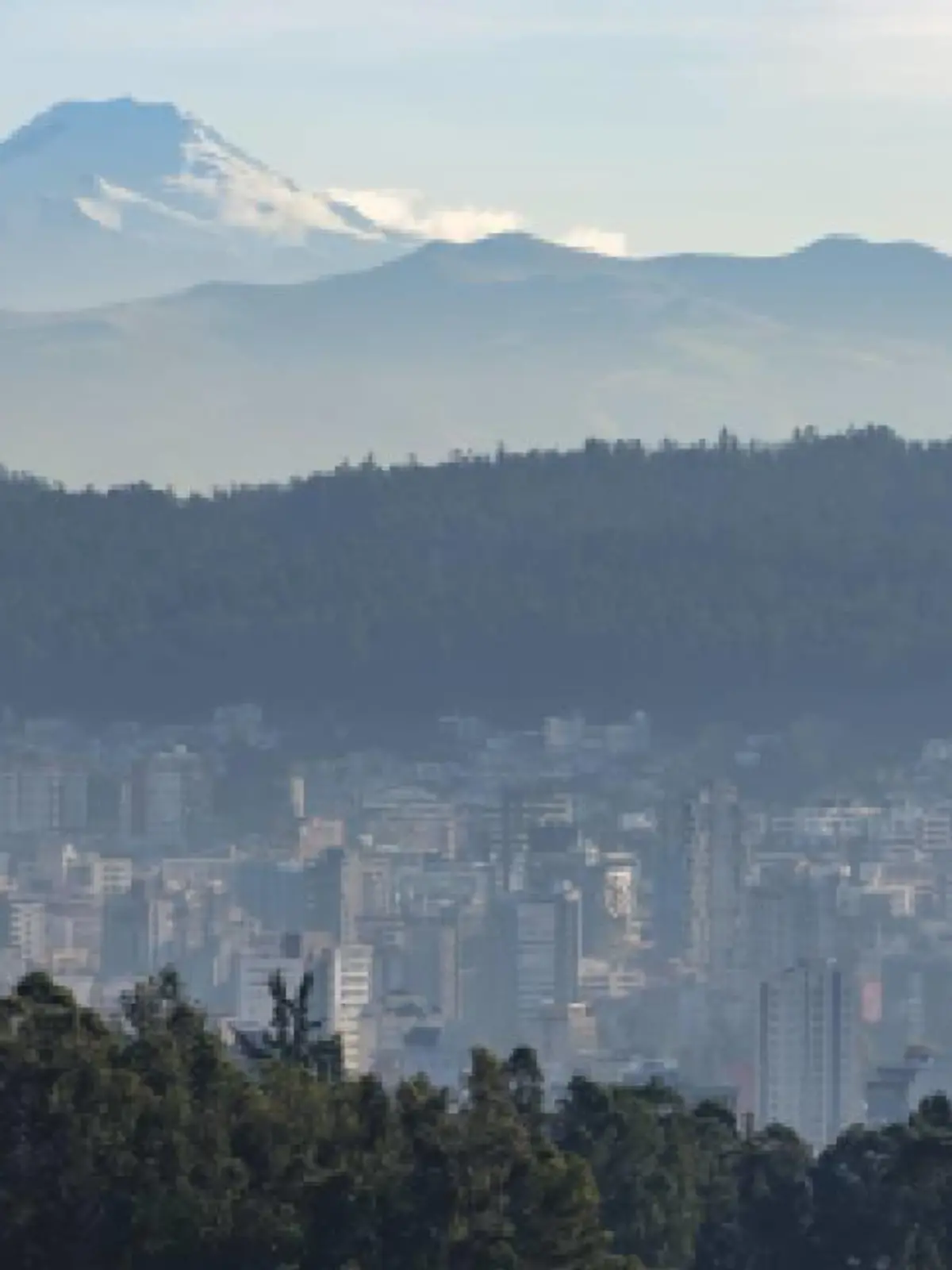 Häuser von Quito, dahinter der Vulkan Cayambe in Ecuador