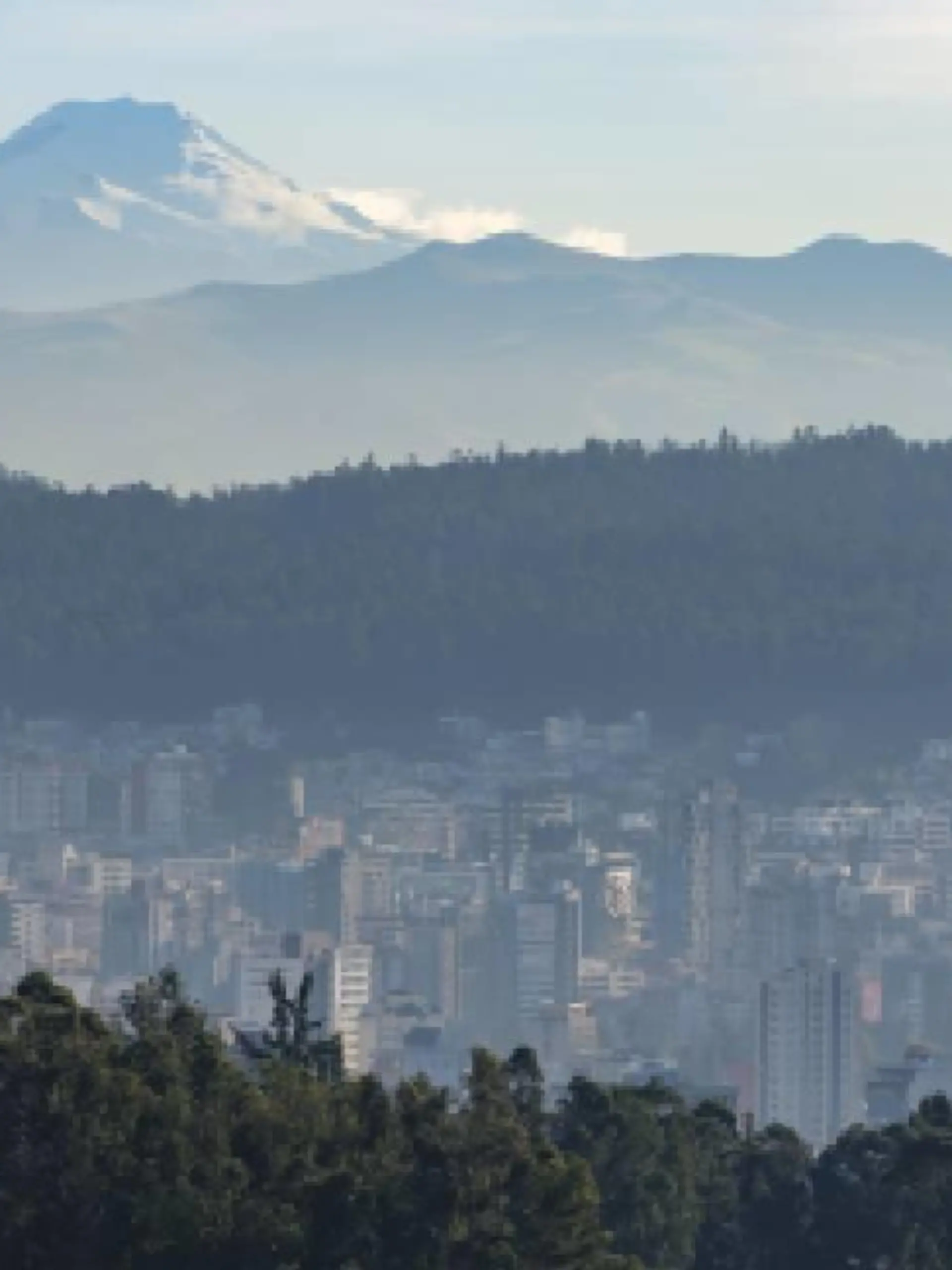 Häuser von Quito, dahinter der Vulkan Cayambe in Ecuador