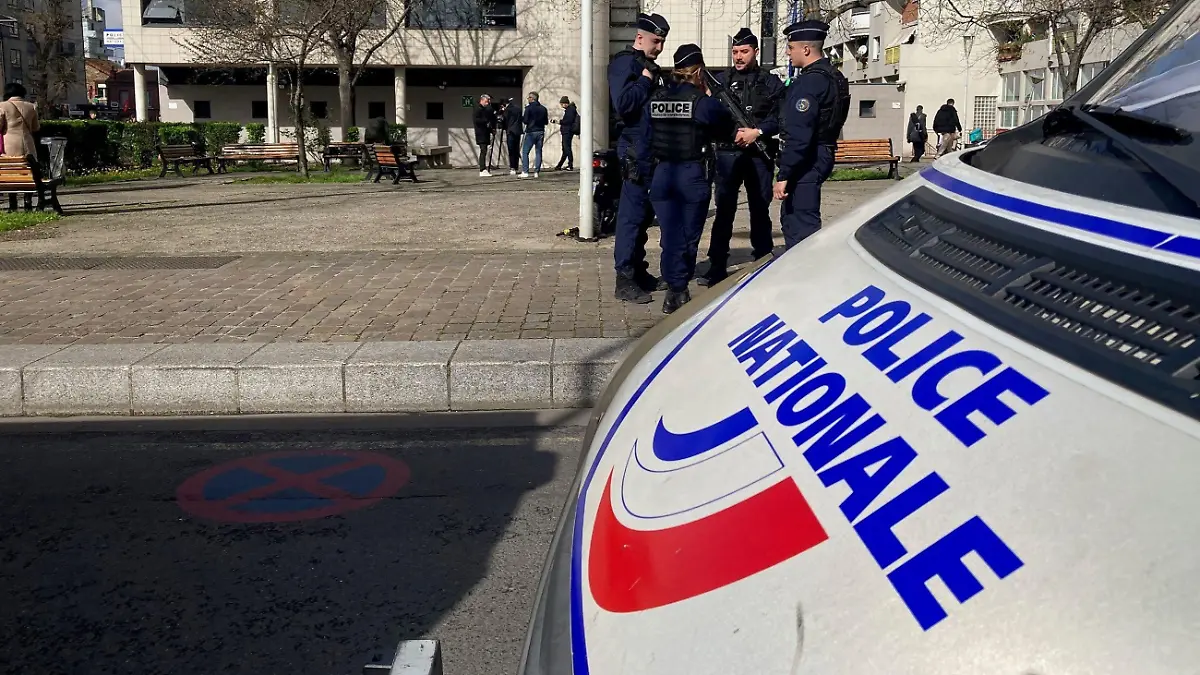18.03.2024, Frankreich, La Courneuve: Polizisten und Journalisten stehen vor einem Polizeirevier in einem nördlichen Vorort von Paris. Einen Tag zuvor war die Wache Ziel eines Brandanschlags. Nach dem Tod eines 18-Jährigen bei einem Polizeieinsatz bei Paris hatten Dutzende junge Leute am späten Sonntagabend die Wache mit Feuerwerkskörpern und Molotowcocktails attackiert. Foto: Clotilde Gourlet/AFP/dpa +++ dpa-Bildfunk +++