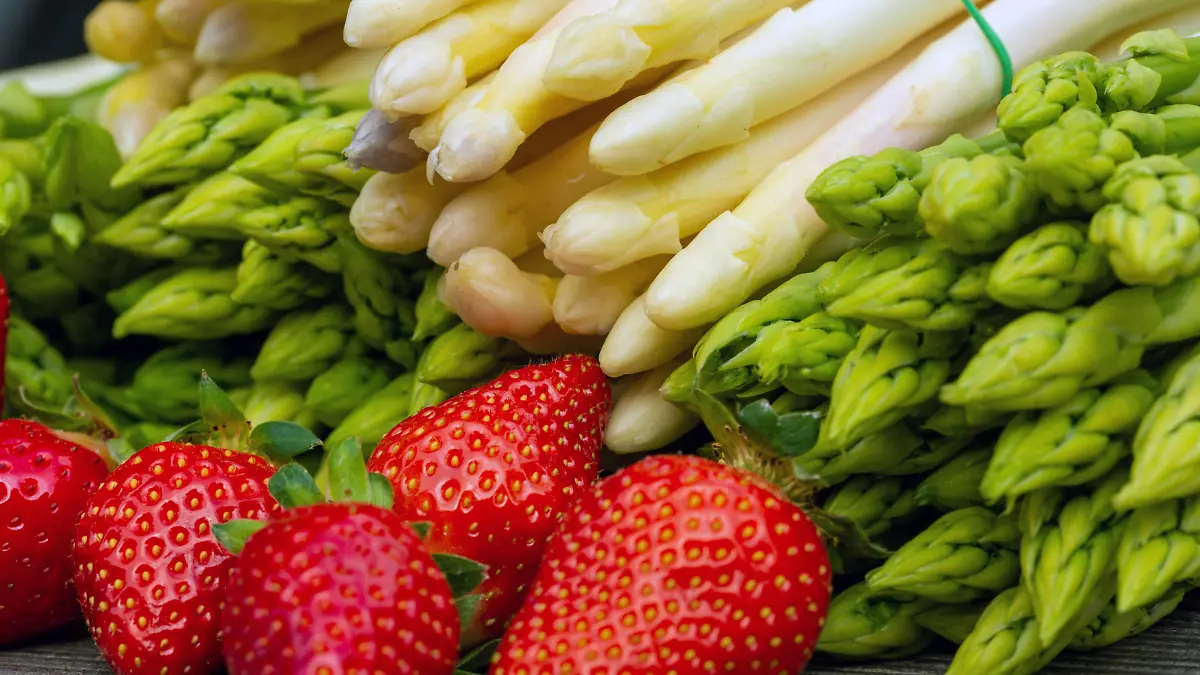 Grüne Spargel, weiße Spargel und frische Erdbeeren dekoriert auf einem rustikalen Holztisch *** Green asparagus, white asparagus and fresh strawberries decorated on a rustic wooden table Copyright: xx