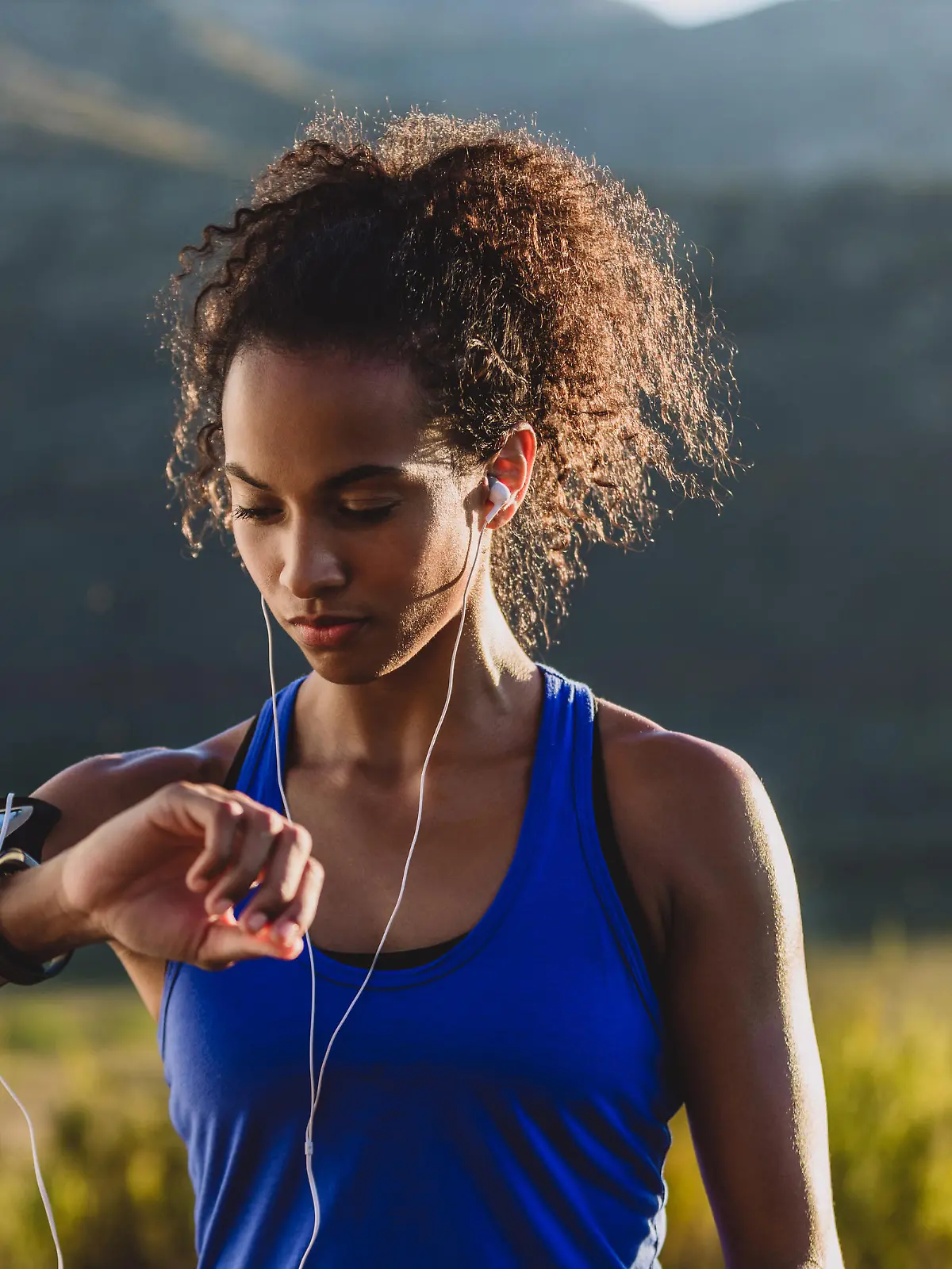 Cropped shot of a woman checking her wristwatch while out for a run