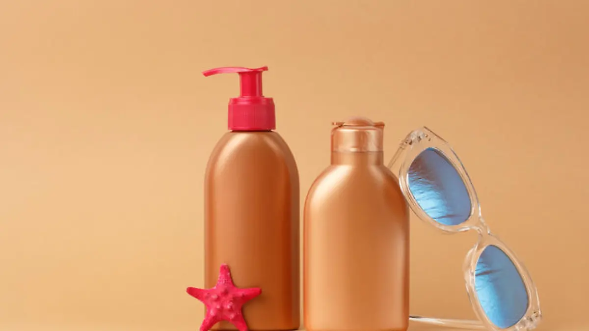 Sunblock ads, sun protection cosmetic products design with moisturizer cream or liquid lotion on bronze, light brown background. Facial and body skin care on the beach, at sea, on summer vacation.