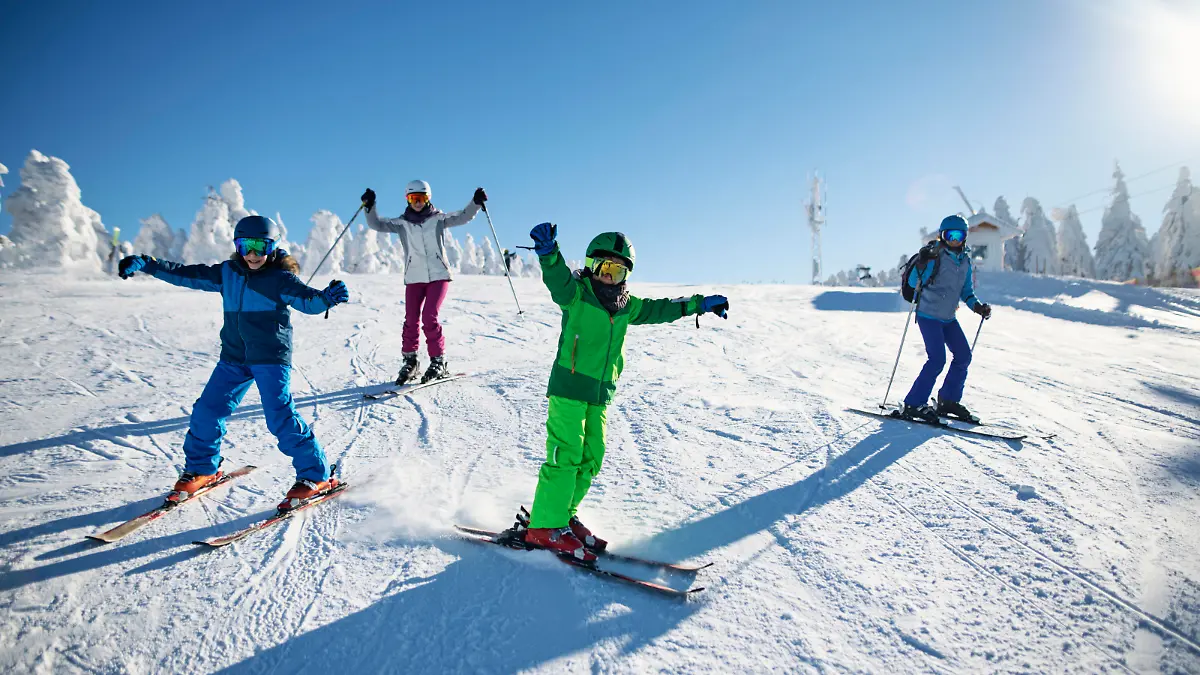 Mother with kids are skiing together down the ski slope. Everybody is laughing happily. 
Sunny winter day.
Nikon D850