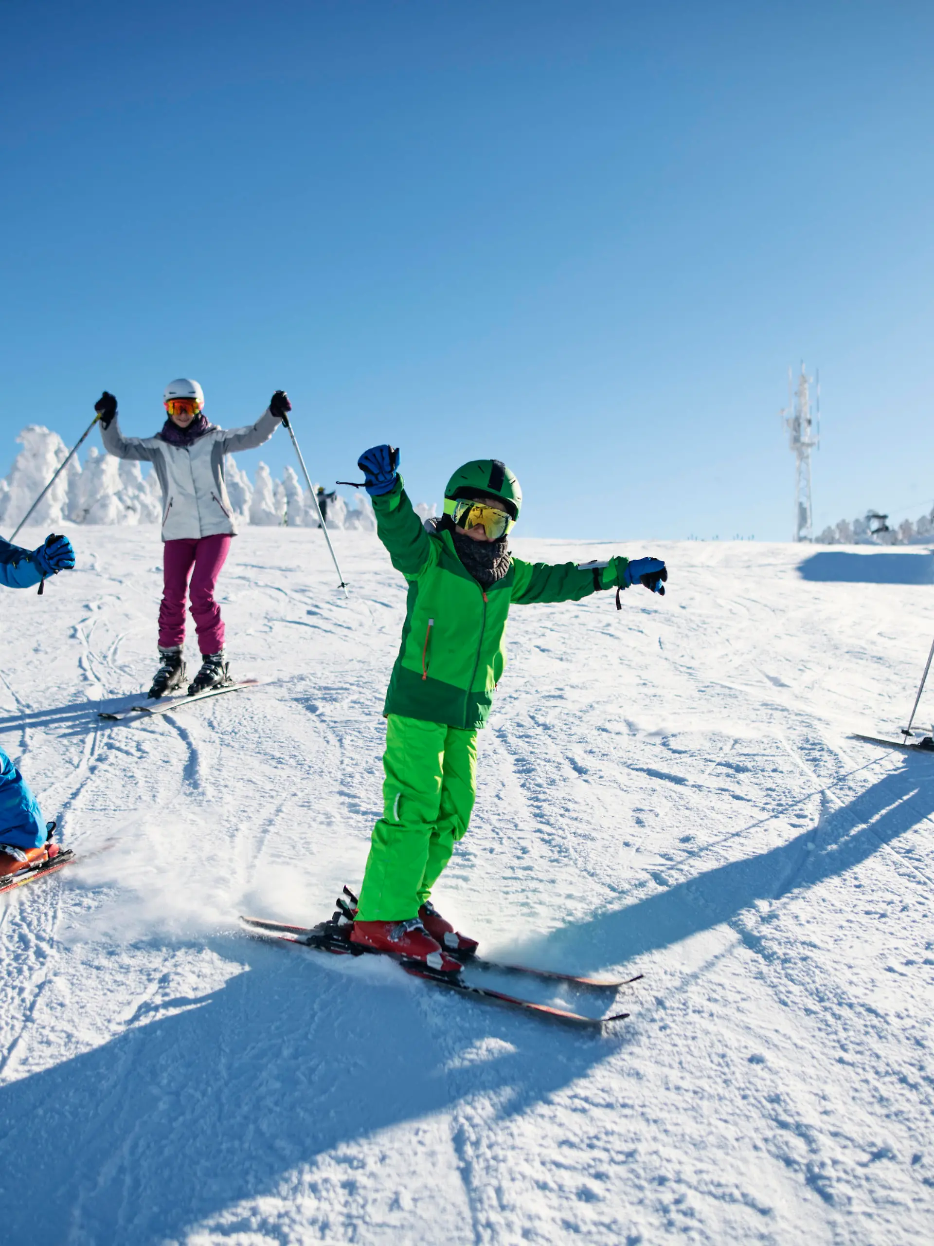 Mother with kids are skiing together down the ski slope. Everybody is laughing happily. 
Sunny winter day.
Nikon D850